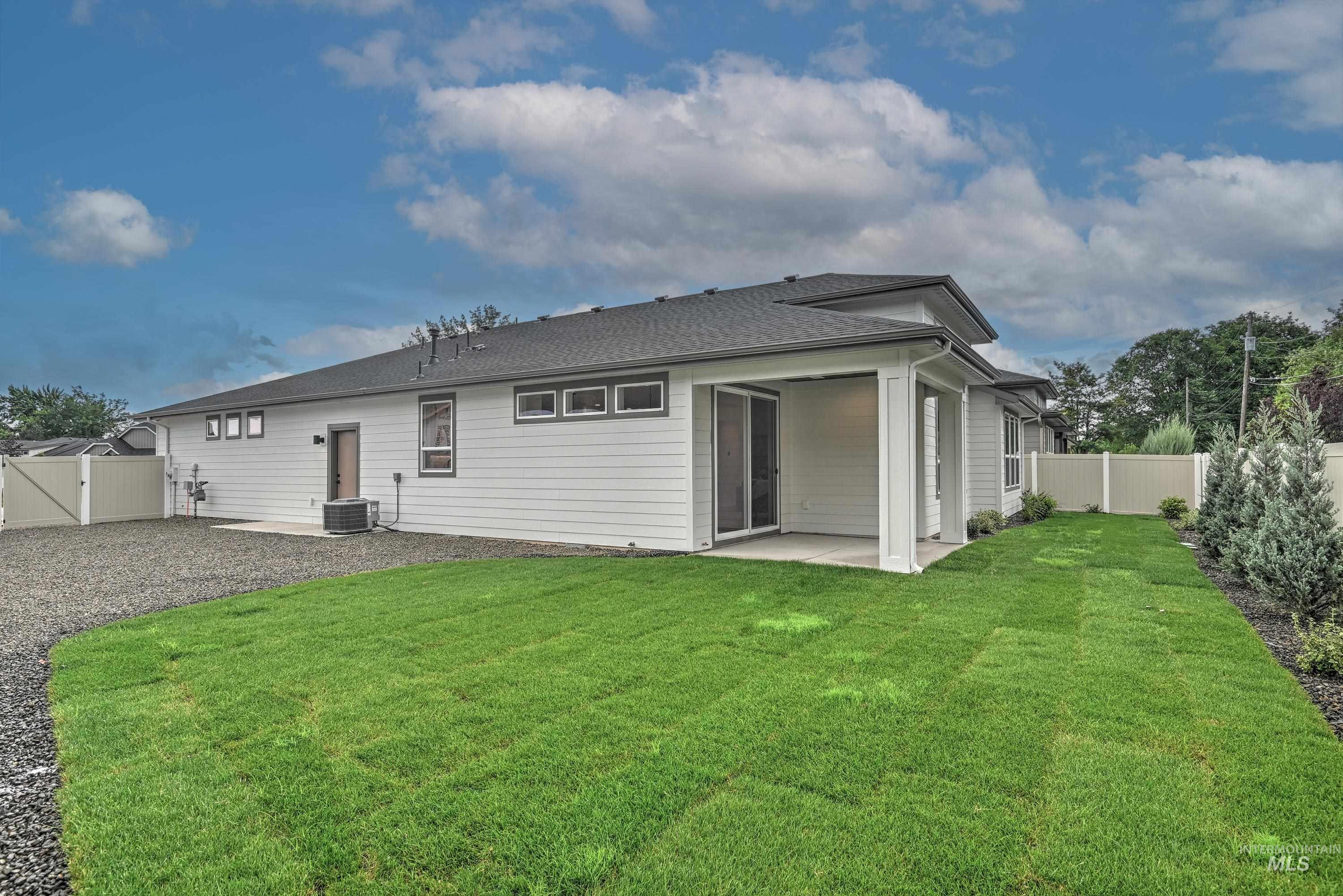Back of property featuring a patio, a fenced backyard, and a gate