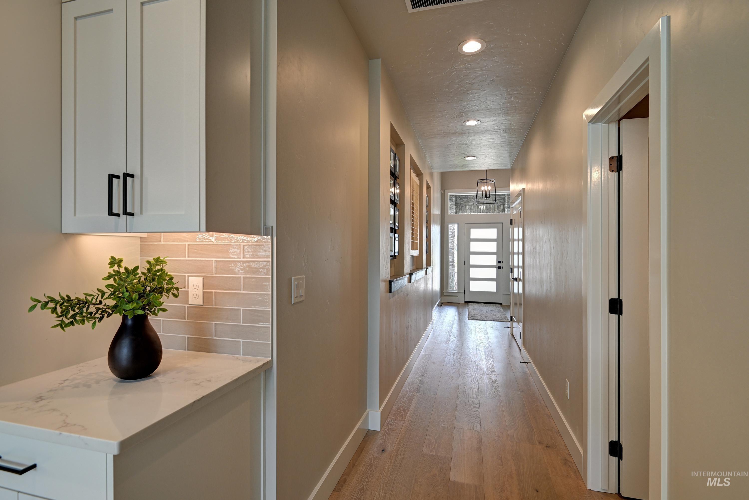 Corridor with recessed lighting, light wood finished floors, and a textured ceiling