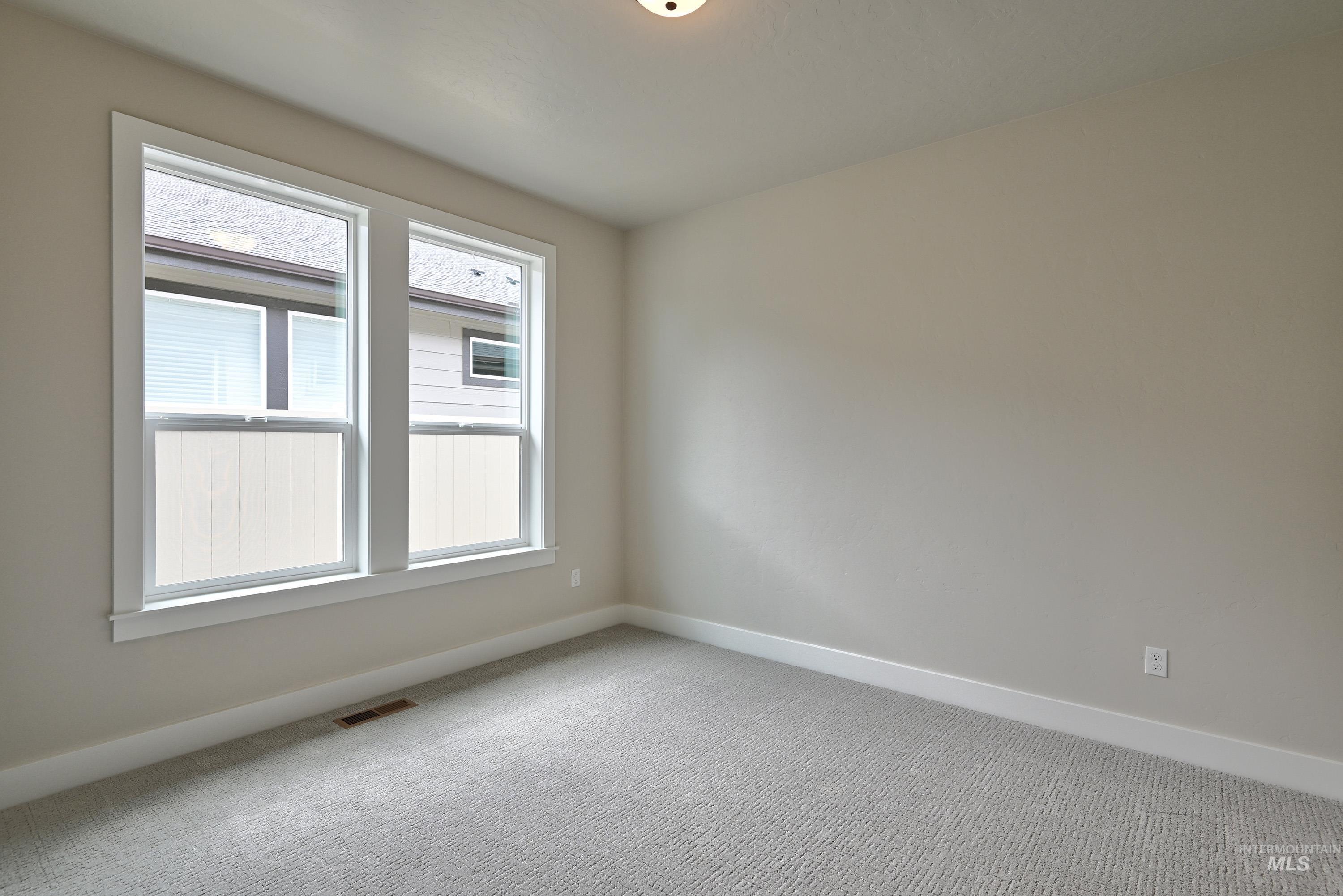 Empty room featuring carpet flooring and healthy amount of natural light