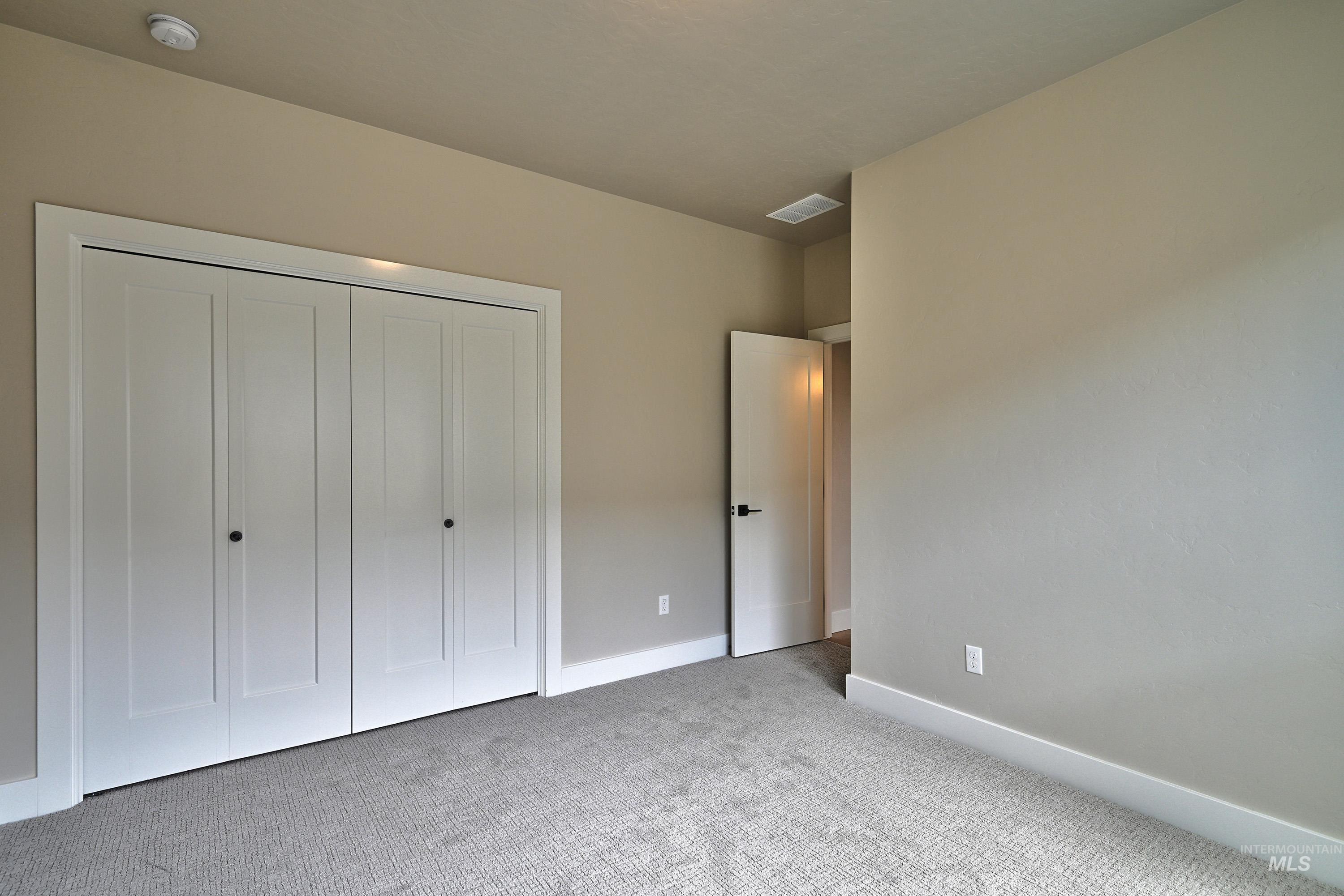 Unfurnished bedroom featuring carpet and a closet