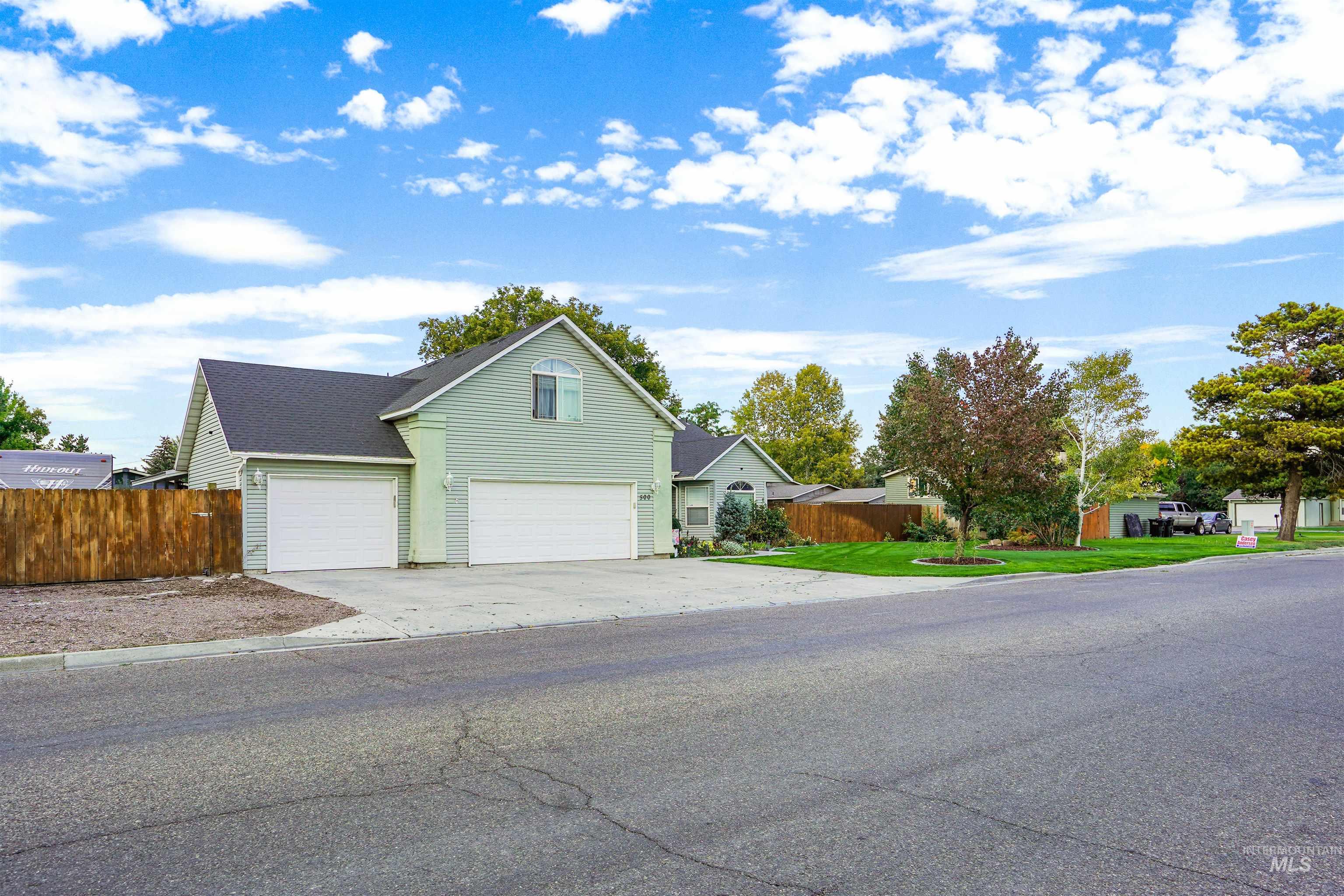 View of front of property with concrete driveway and an attached garage