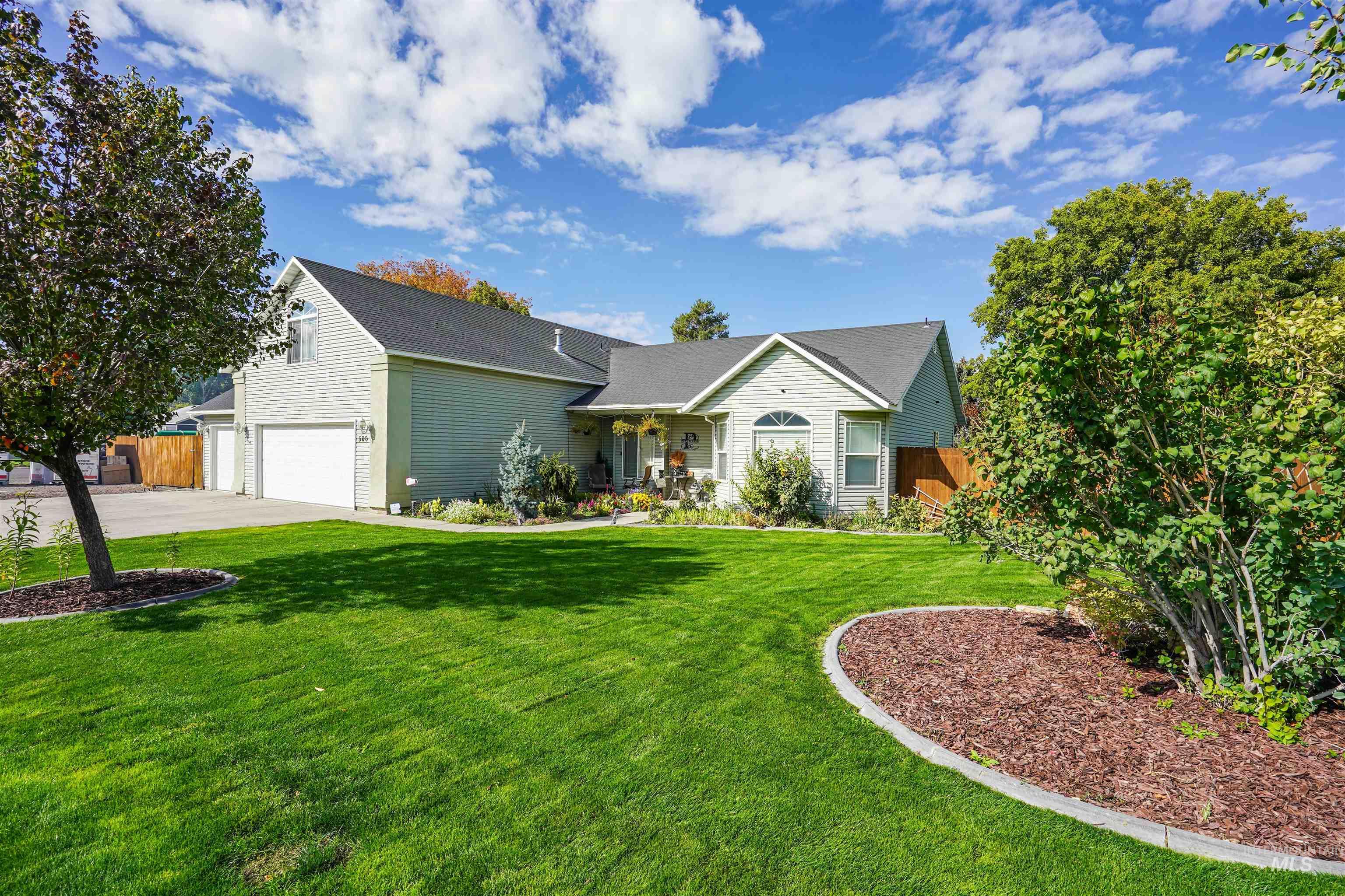 View of front of house with an attached garage, driveway, and covered porch
