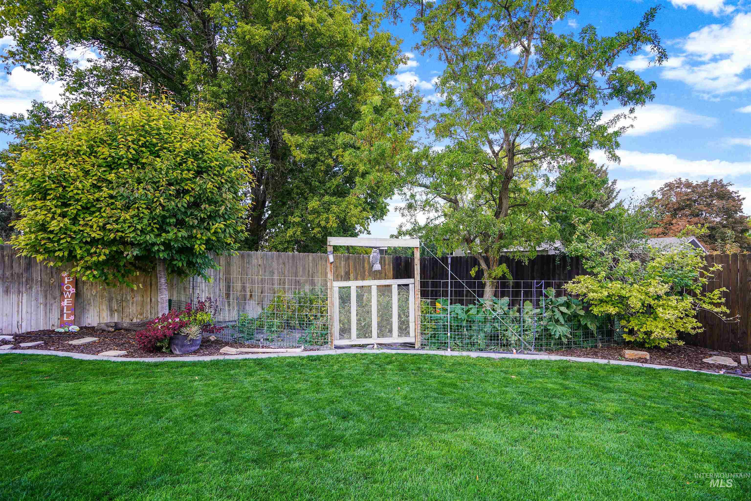 Fenced backyard featuring a vegetable garden