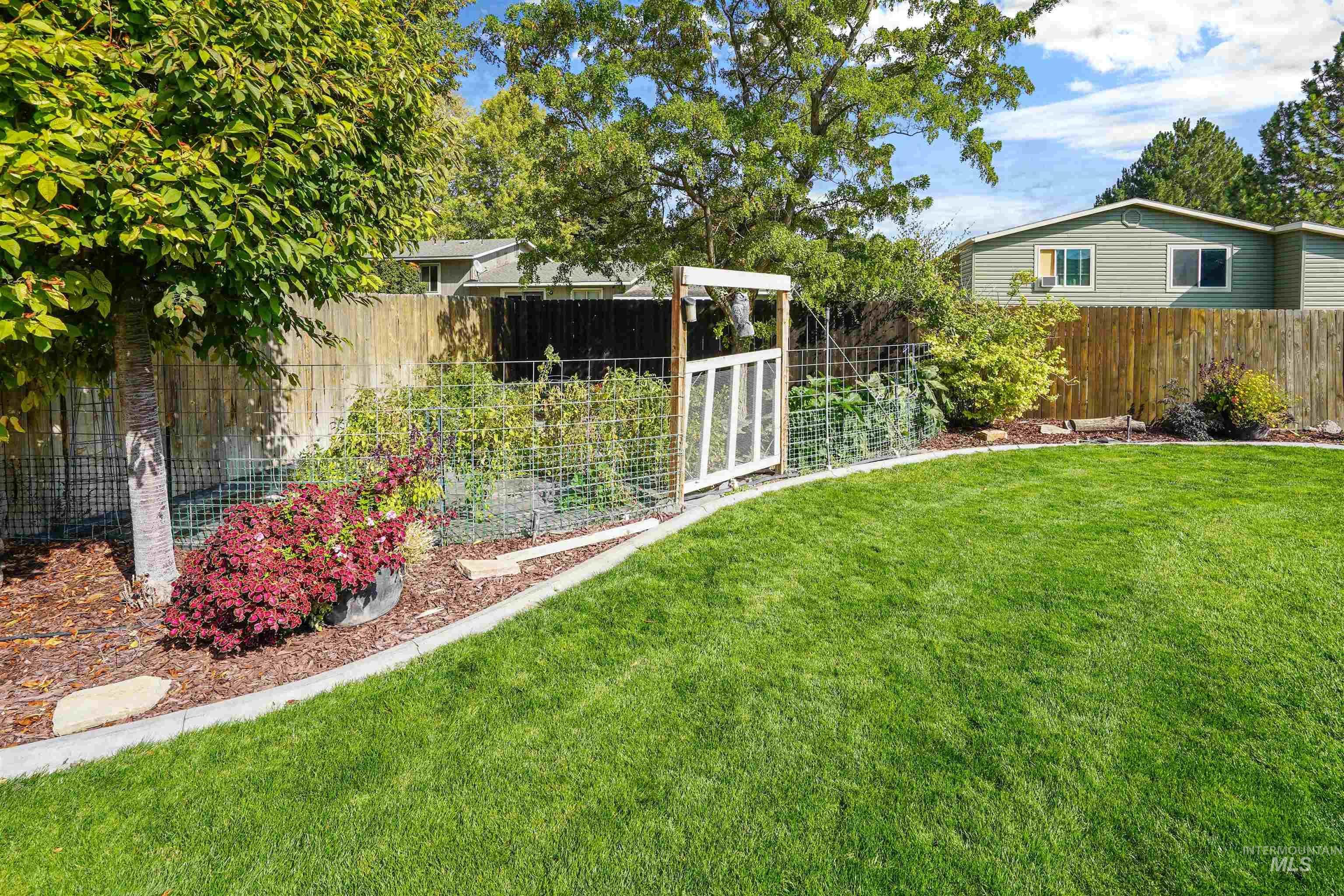 Fenced backyard featuring a vegetable garden
