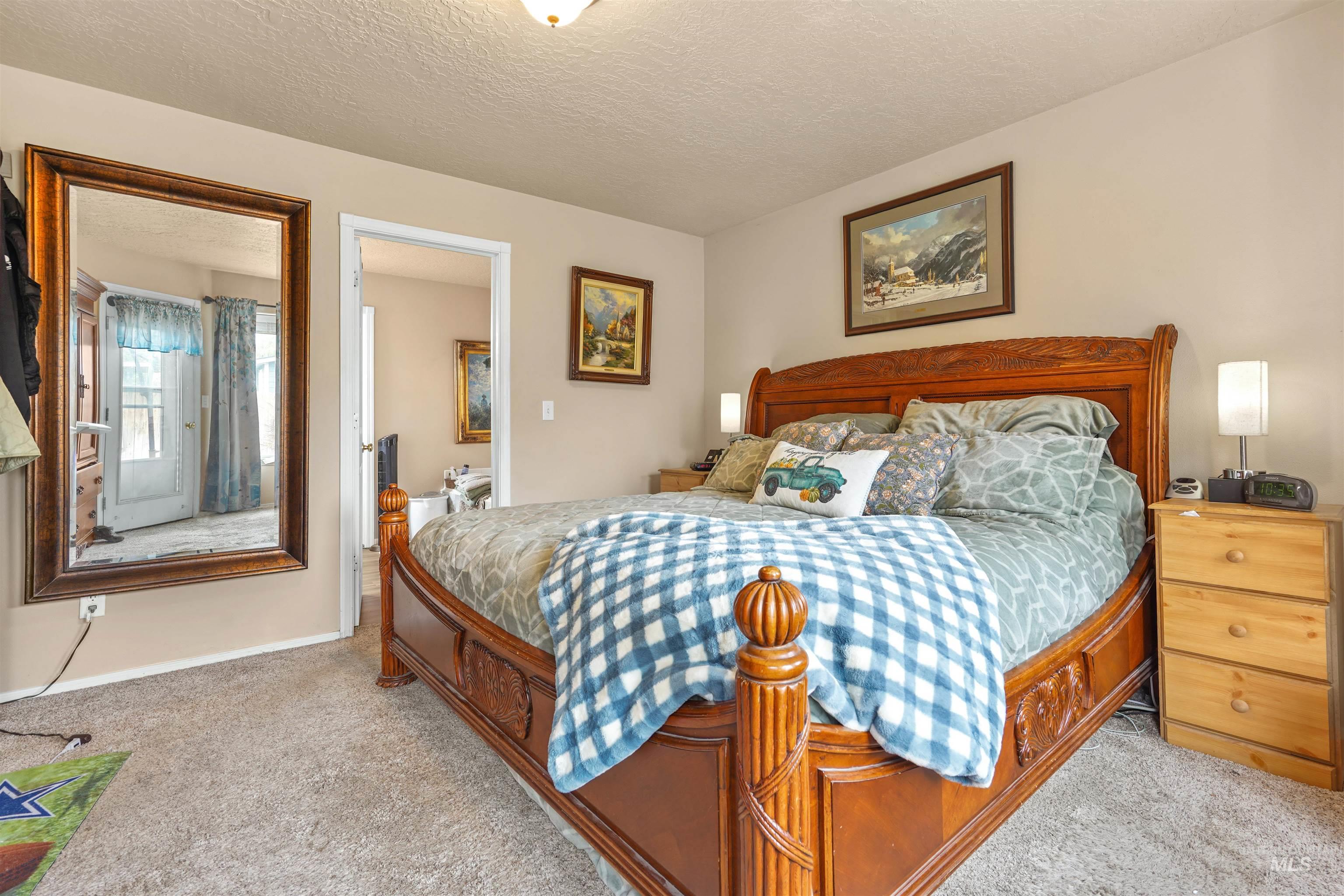 Bedroom featuring a textured ceiling and light colored carpet