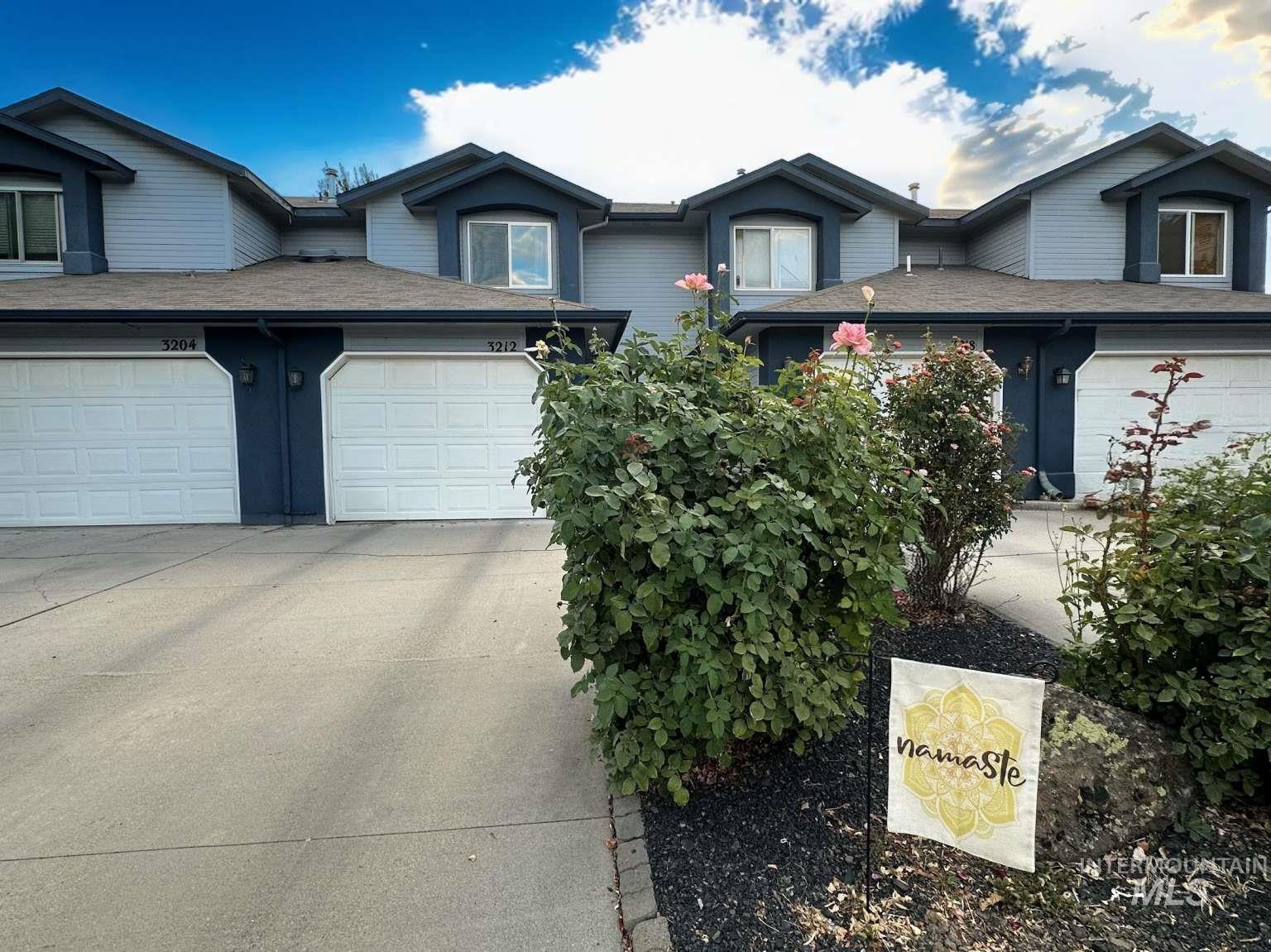 Traditional-style home featuring a garage, concrete driveway, and roof with shingles