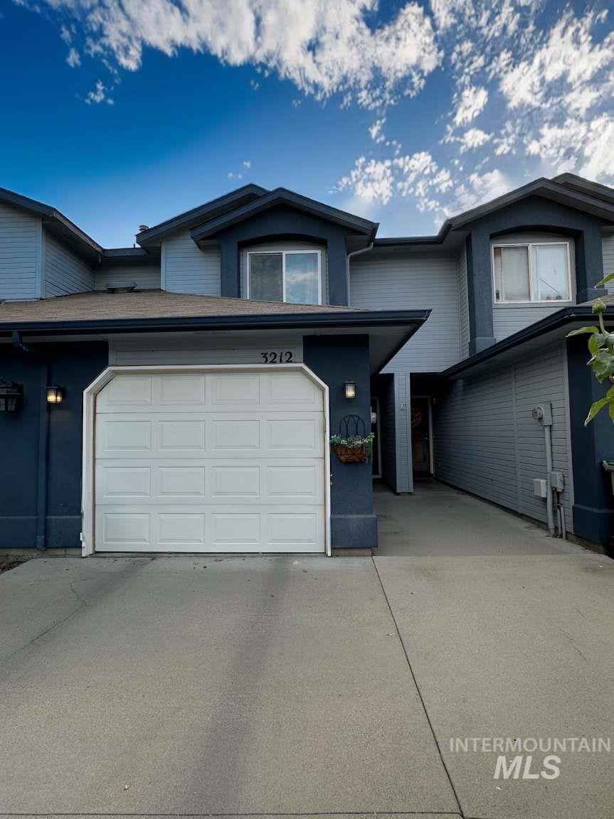 View of front of property with concrete driveway and a garage
