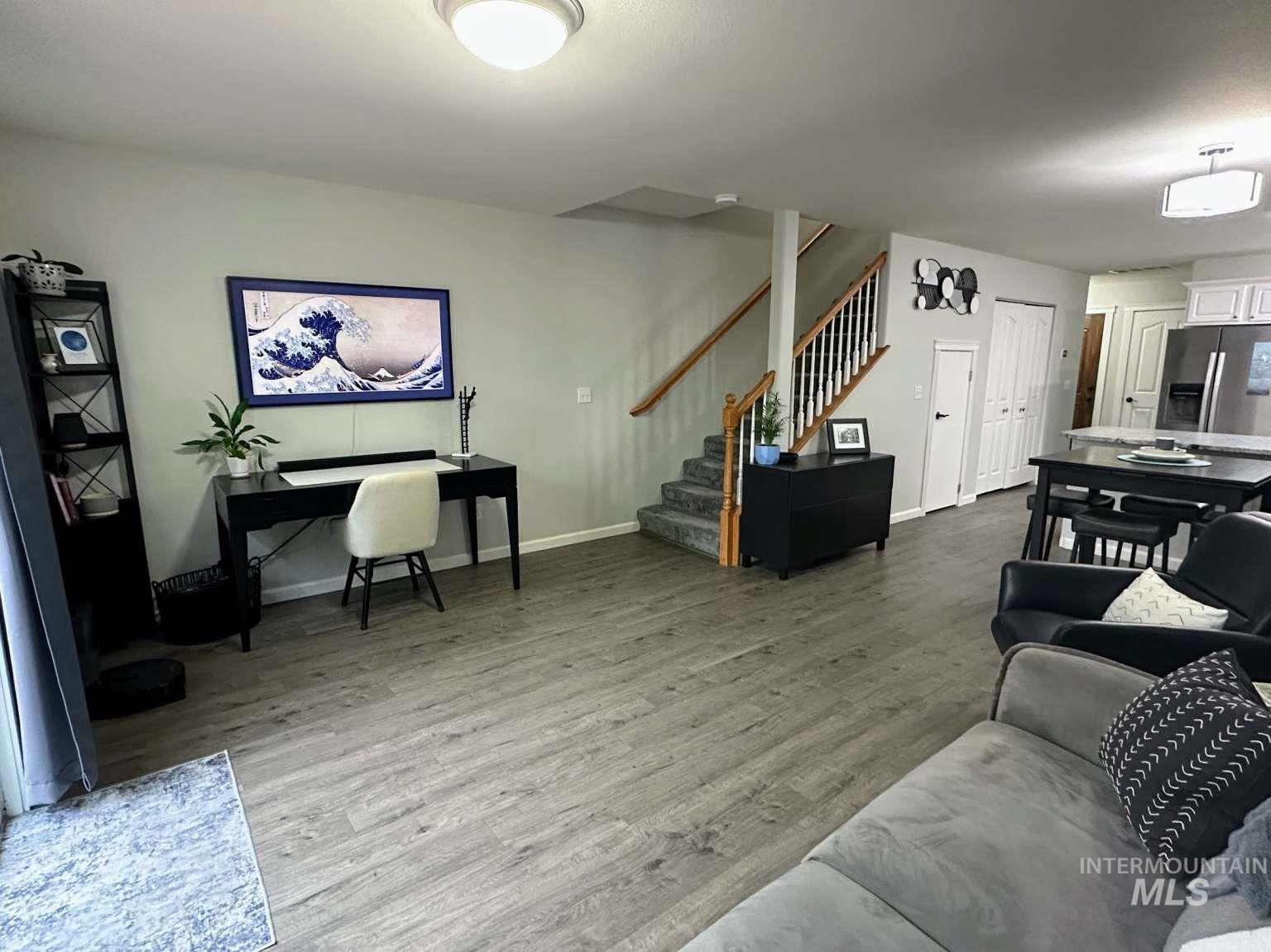 Living area with light wood-type flooring and stairway