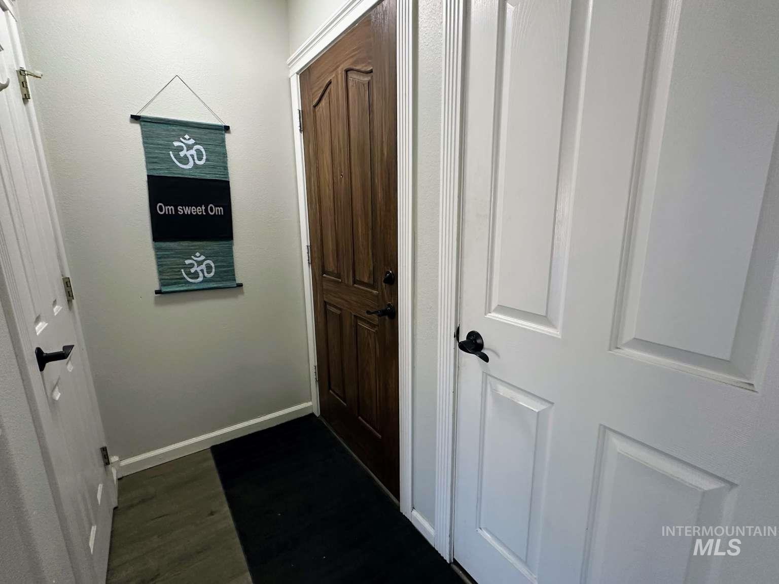 Doorway featuring wood finished floors and baseboards