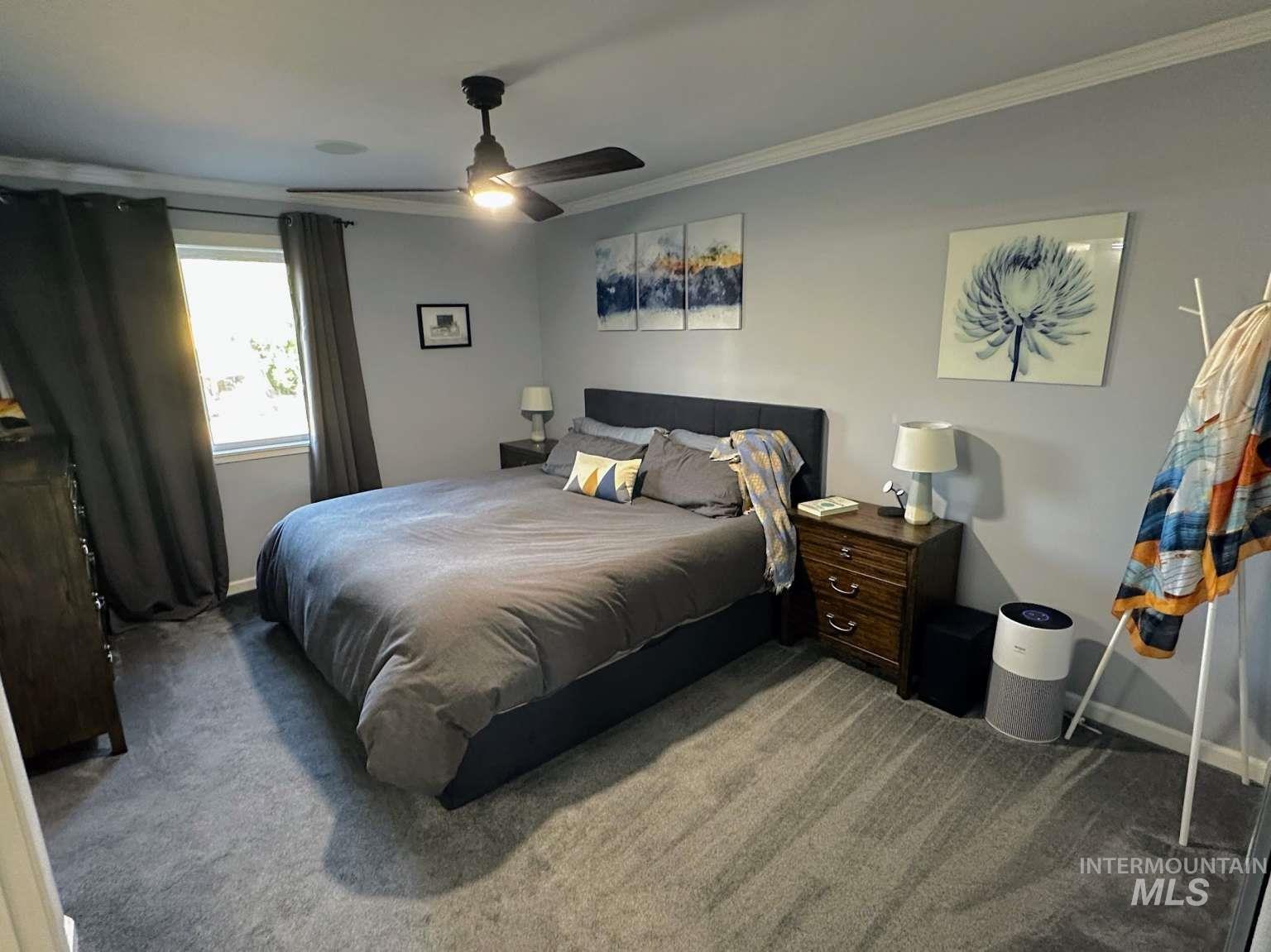 Bedroom featuring ornamental molding, carpet floors, and ceiling fan