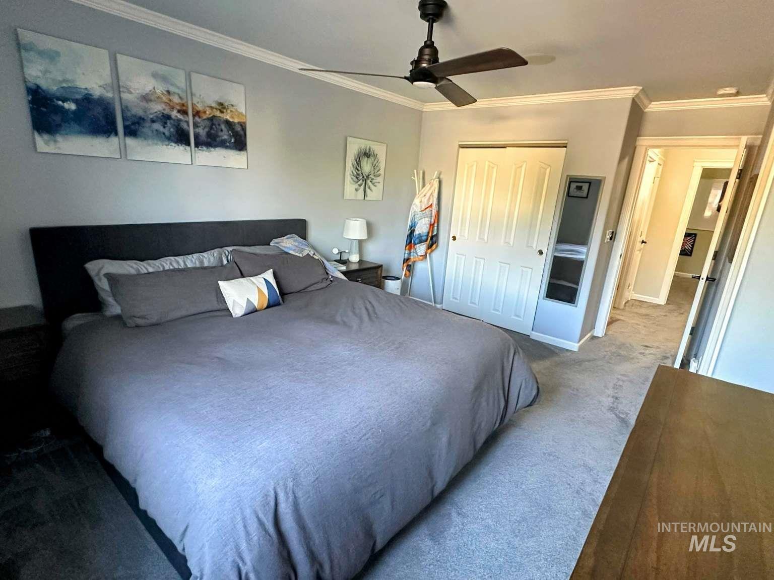 Bedroom featuring crown molding, carpet, a closet, and a ceiling fan