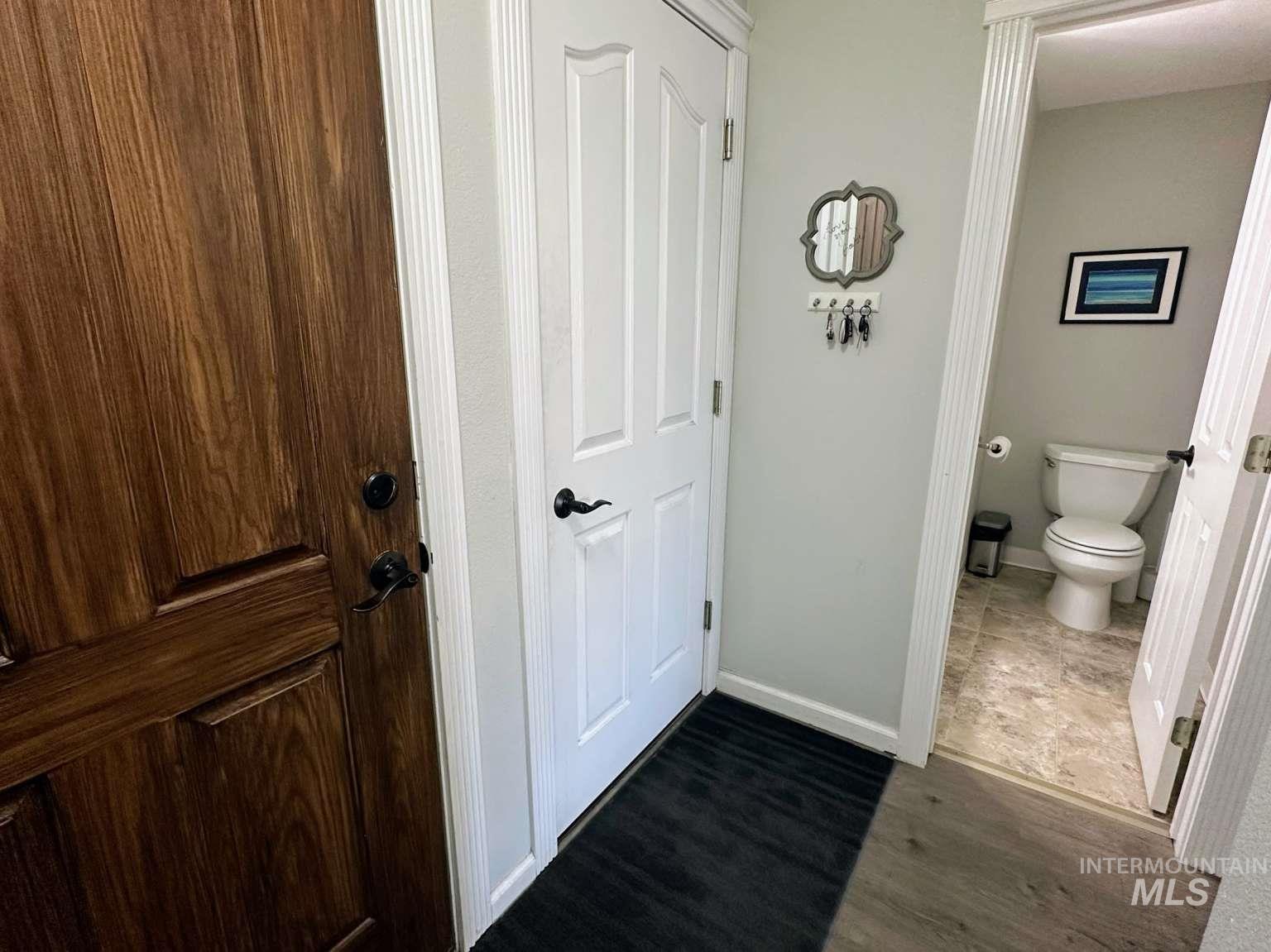 Bathroom featuring baseboards and dark wood-style flooring