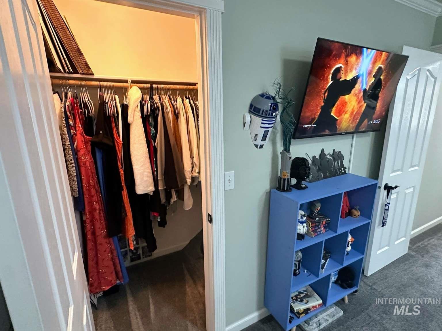 Walk in closet featuring dark carpet