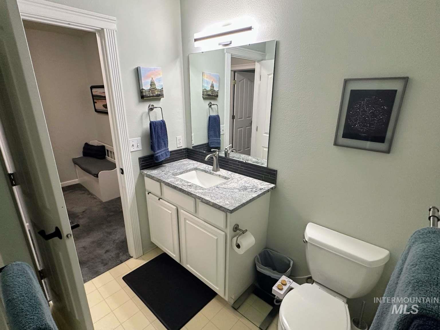 Bathroom featuring vanity, light tile patterned flooring, and light colored carpet