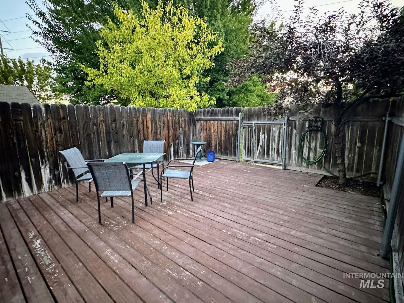 Wooden deck featuring outdoor dining area and a fenced backyard