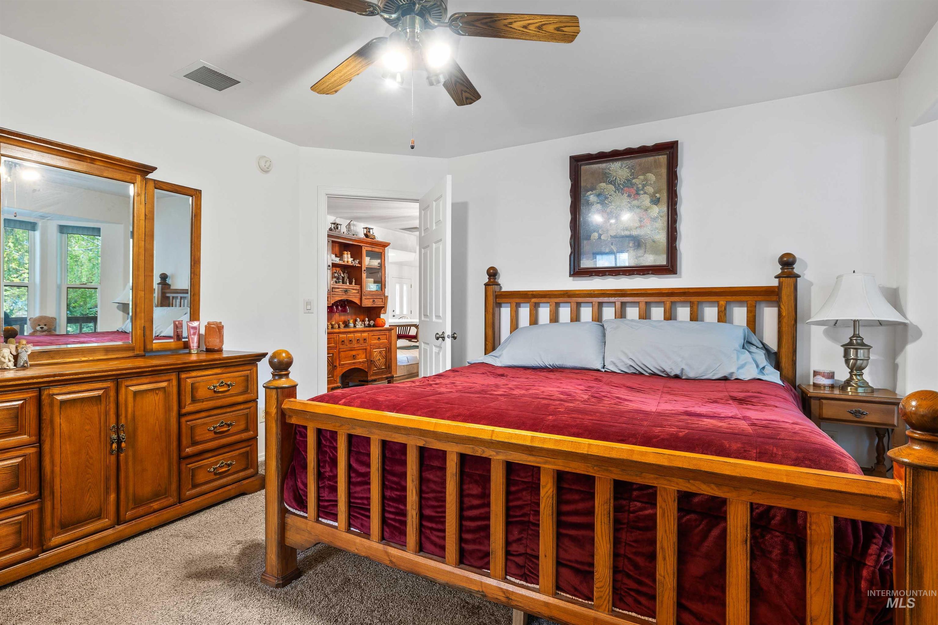 Bedroom featuring light carpet and a ceiling fan