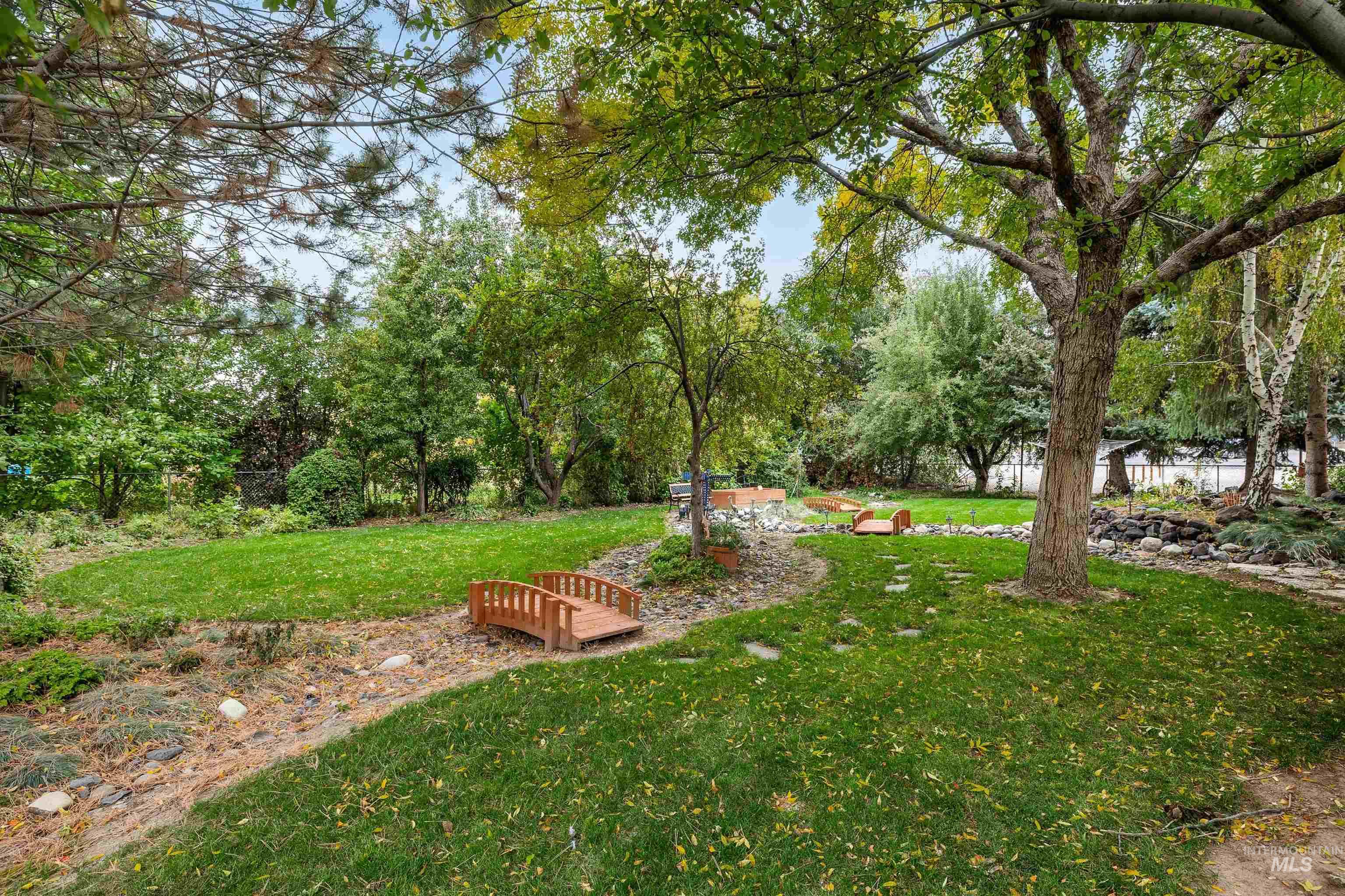 View of grassy yard with view of wooded area