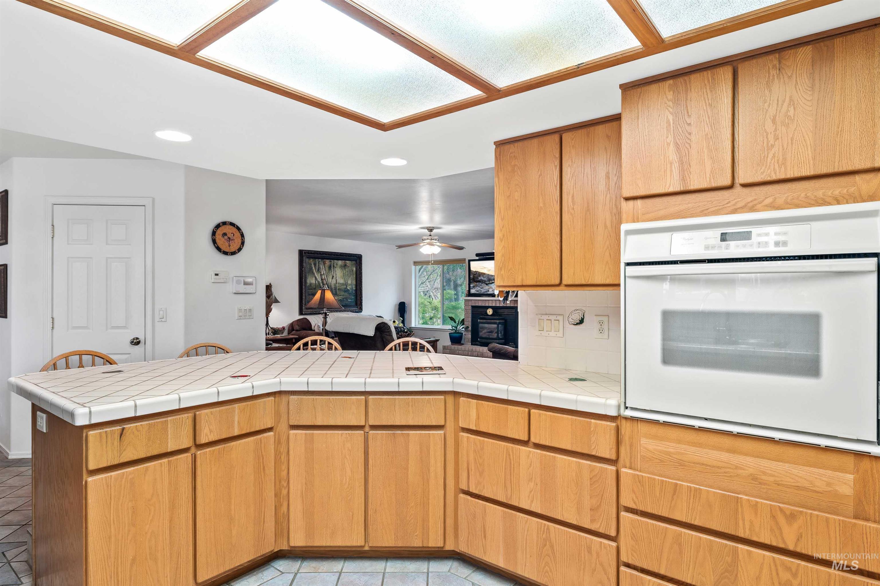 Kitchen featuring recessed lighting, open floor plan, oven, a peninsula, and tile countertops
