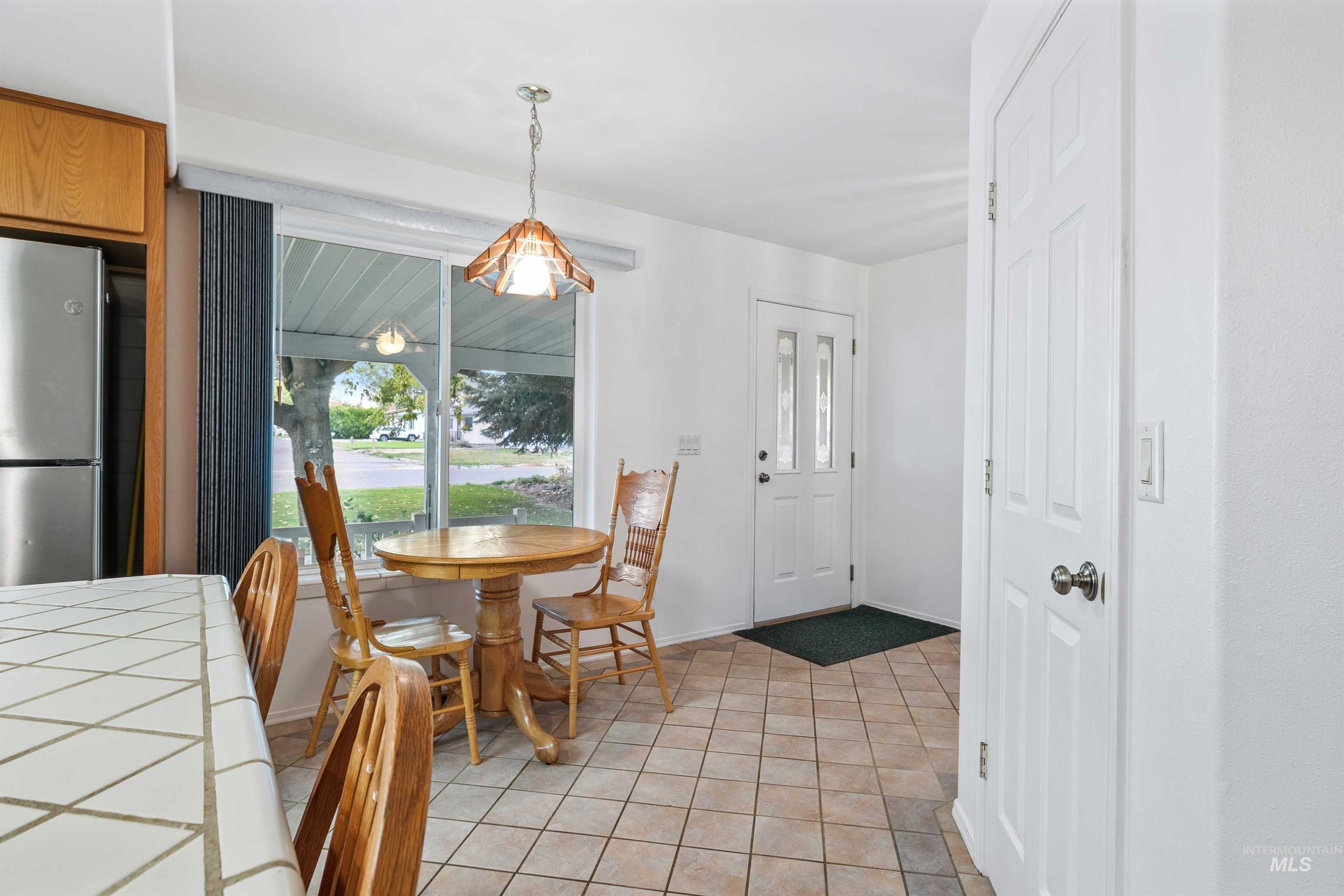 Dining space with light tile patterned flooring and baseboards