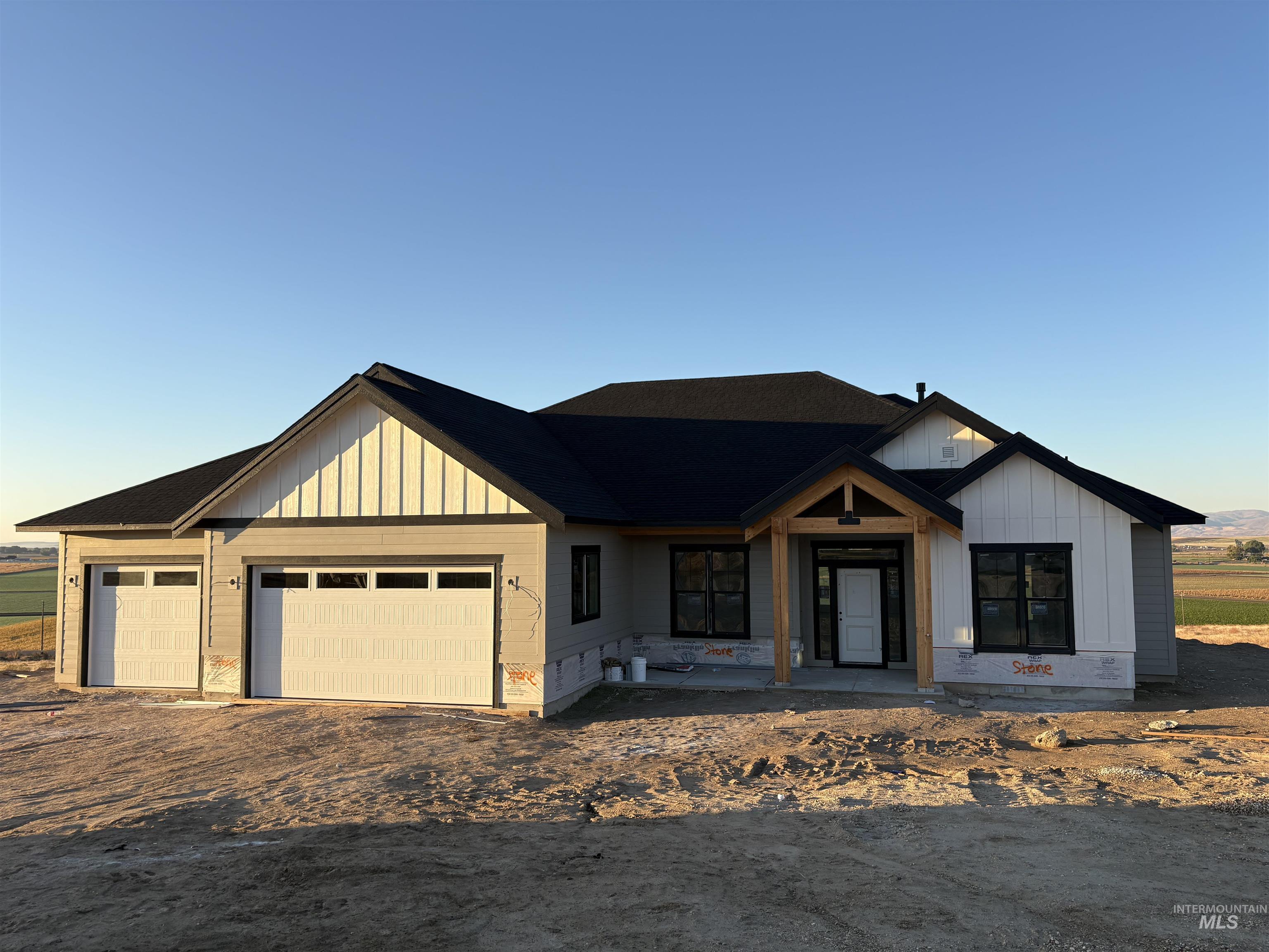 Modern farmhouse featuring board and batten siding, driveway, an attached garage, and covered porch