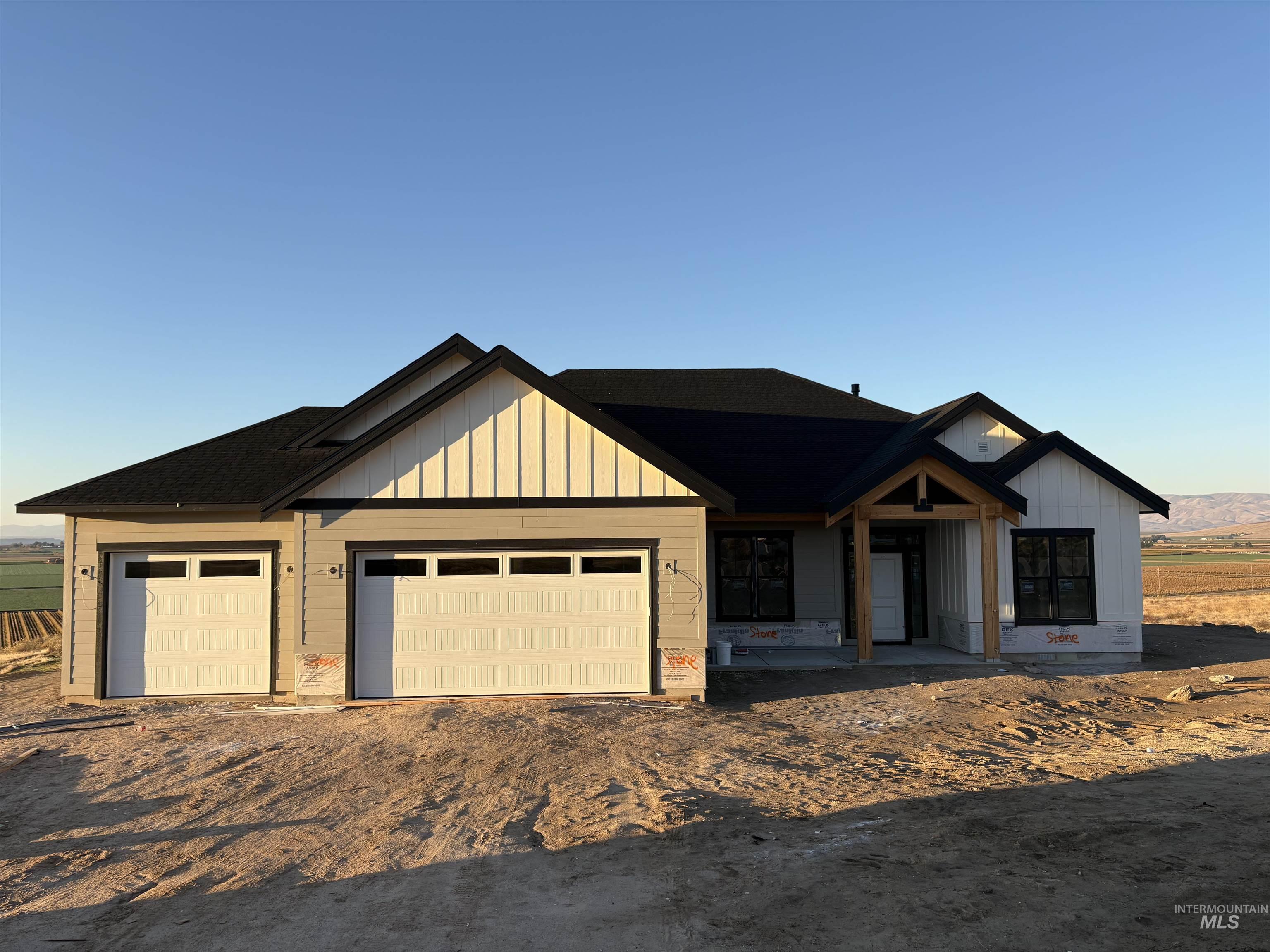 Modern farmhouse style home with board and batten siding, driveway, and an attached garage