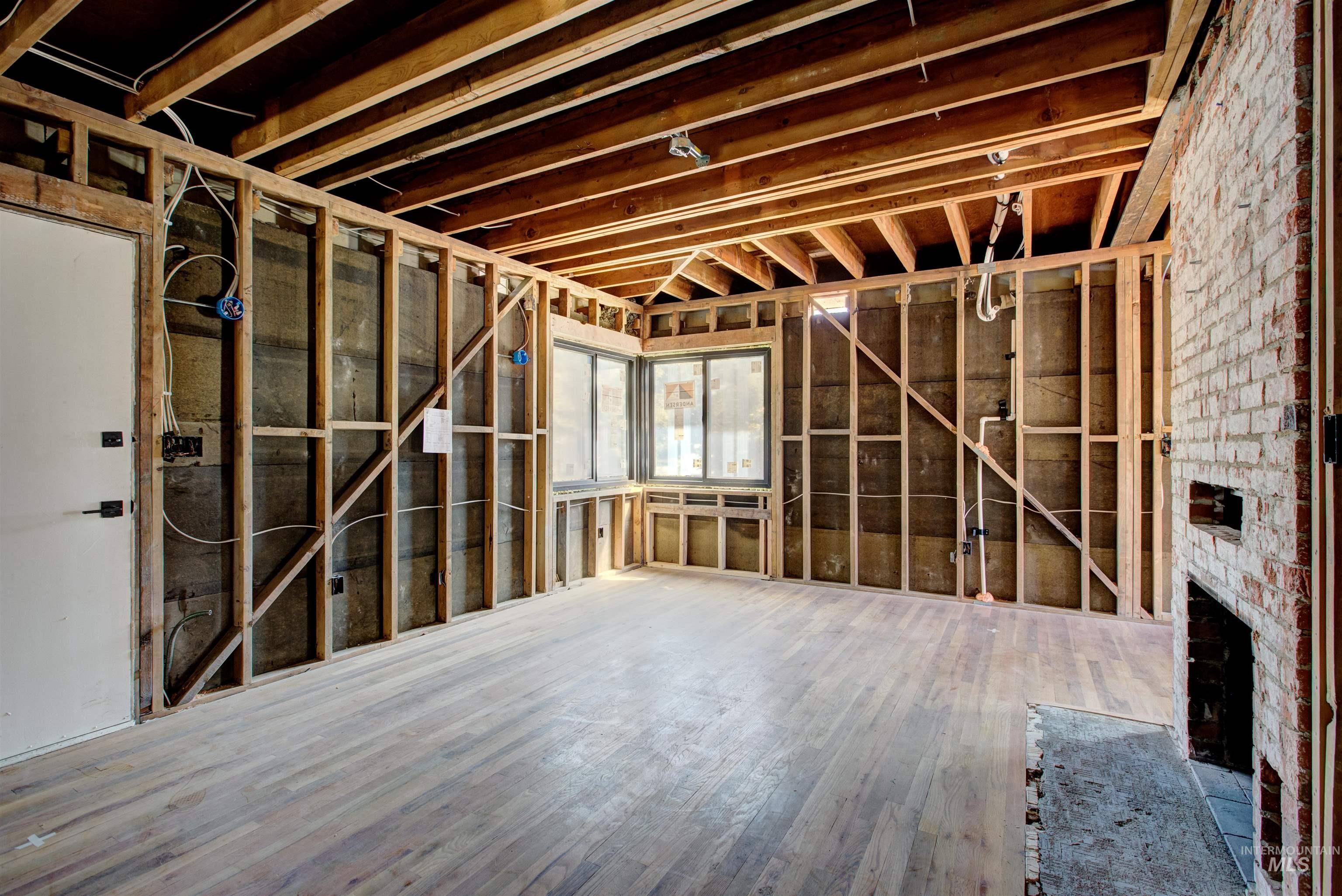 Miscellaneous room featuring a brick fireplace and wood finished floors