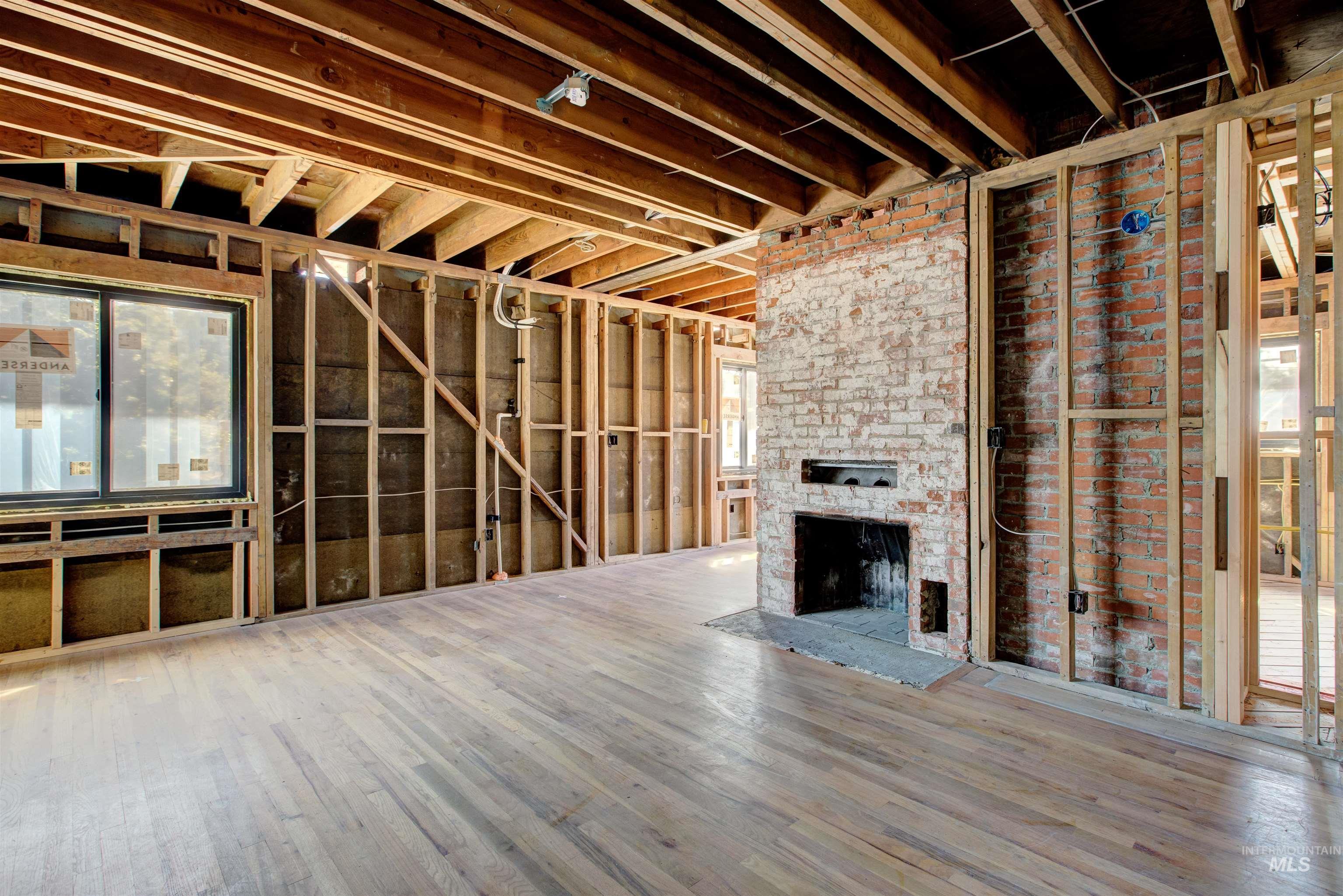 Misc room with healthy amount of natural light, a fireplace, and wood finished floors