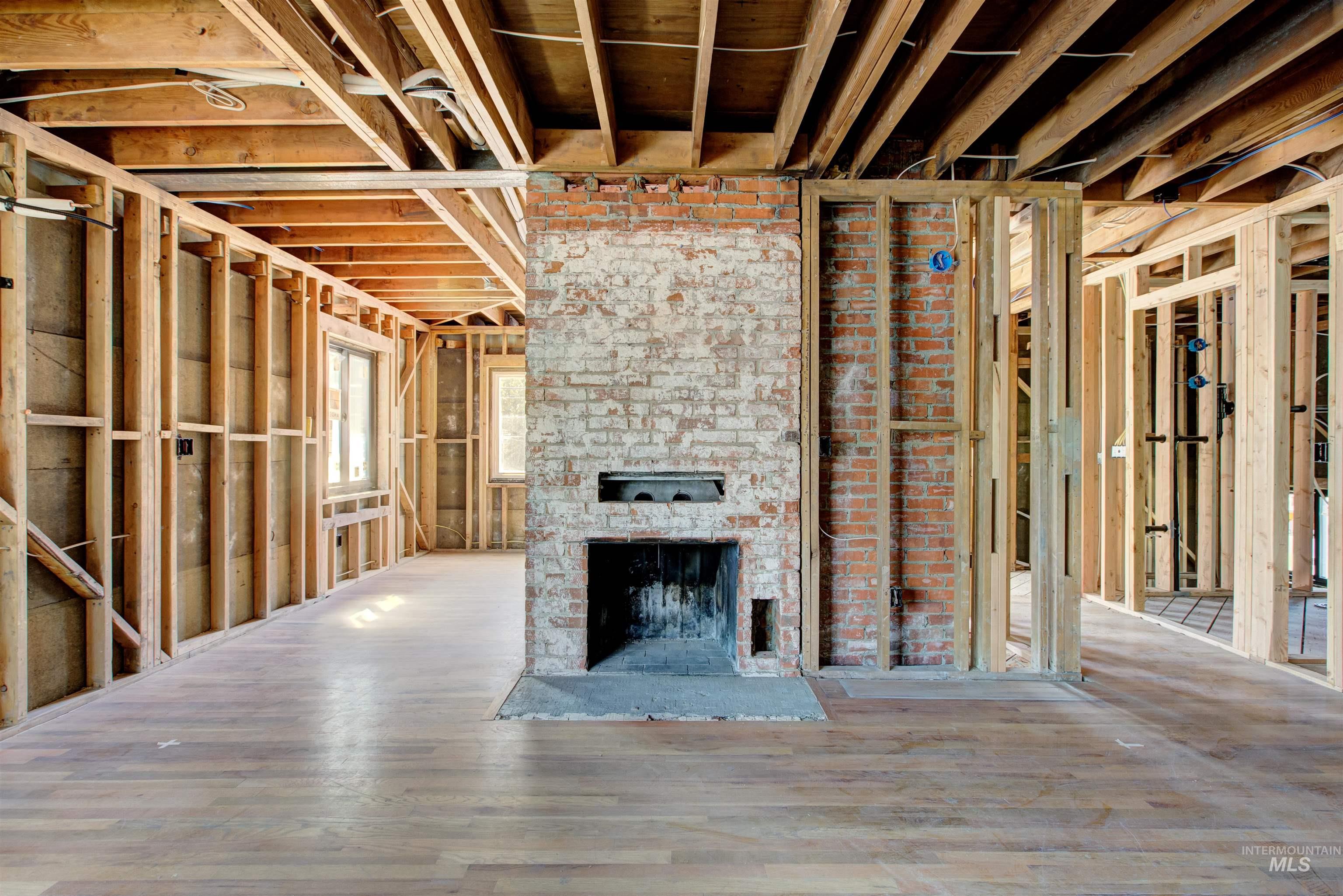 Unfurnished living room featuring a brick fireplace and wood finished floors