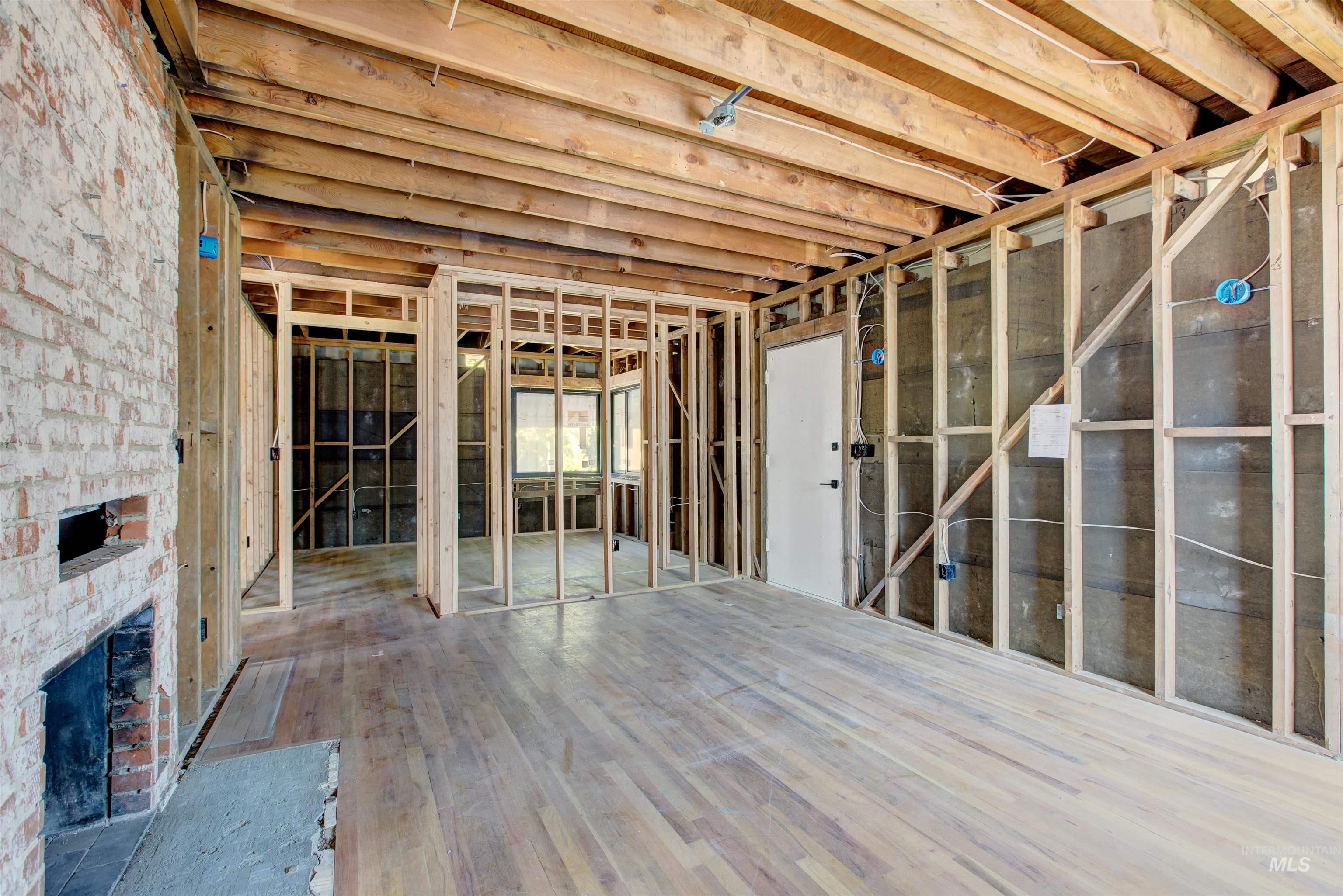 Miscellaneous room with an outdoor brick fireplace and wood finished floors
