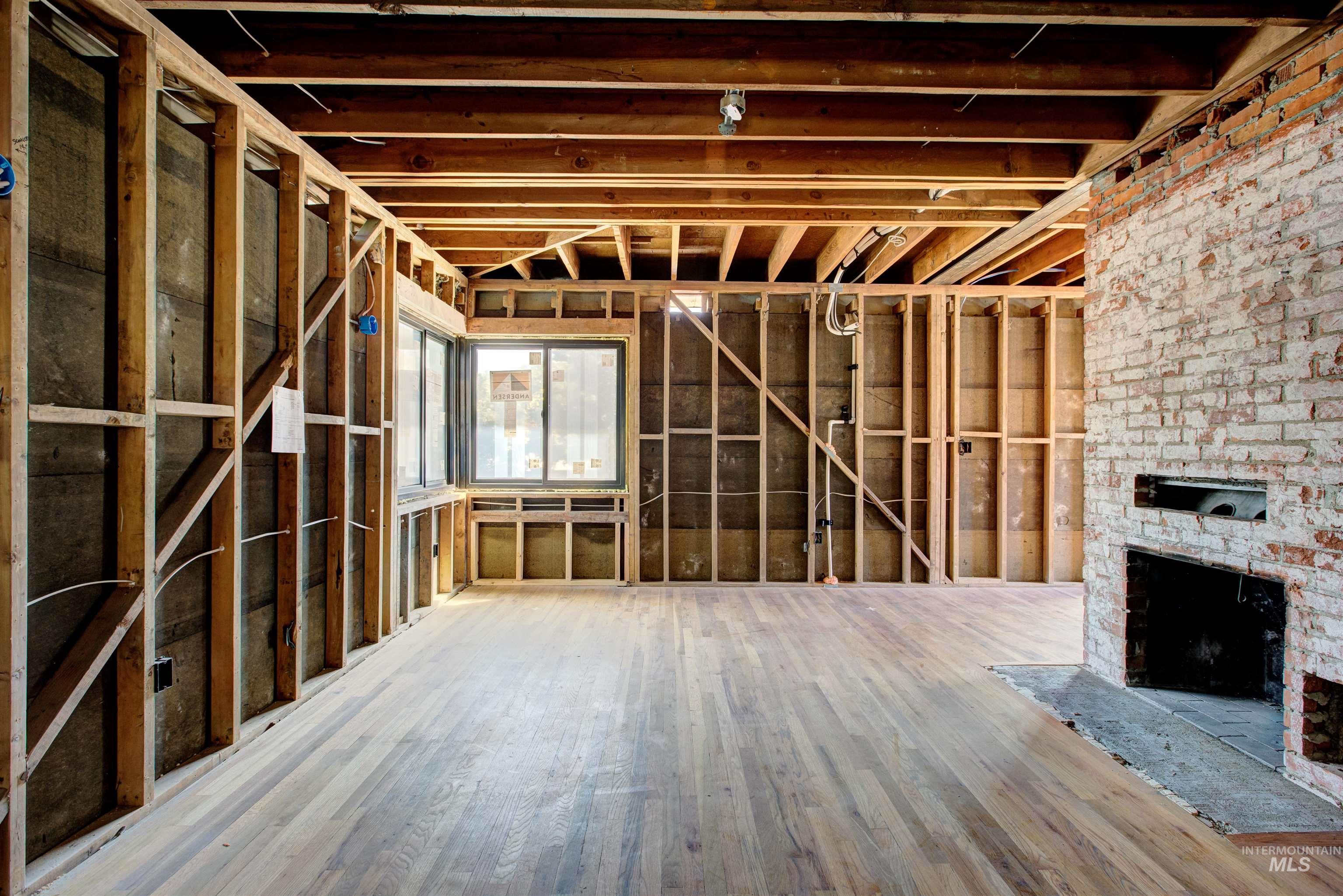 Misc room with a large fireplace and wood finished floors