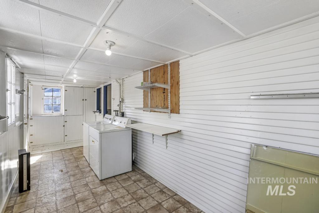 Laundry area featuring wood walls and washing machine and clothes dryer