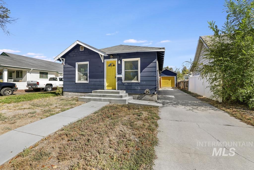Bungalow-style house featuring an outbuilding and driveway