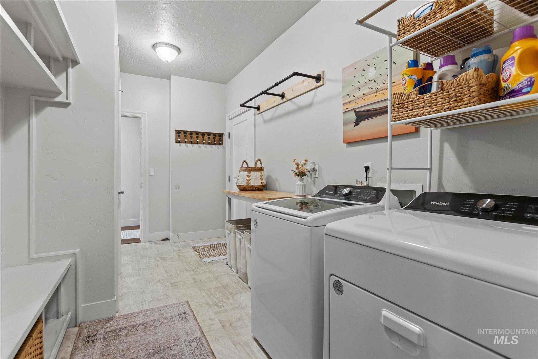 Laundry room featuring washer and dryer and a textured ceiling