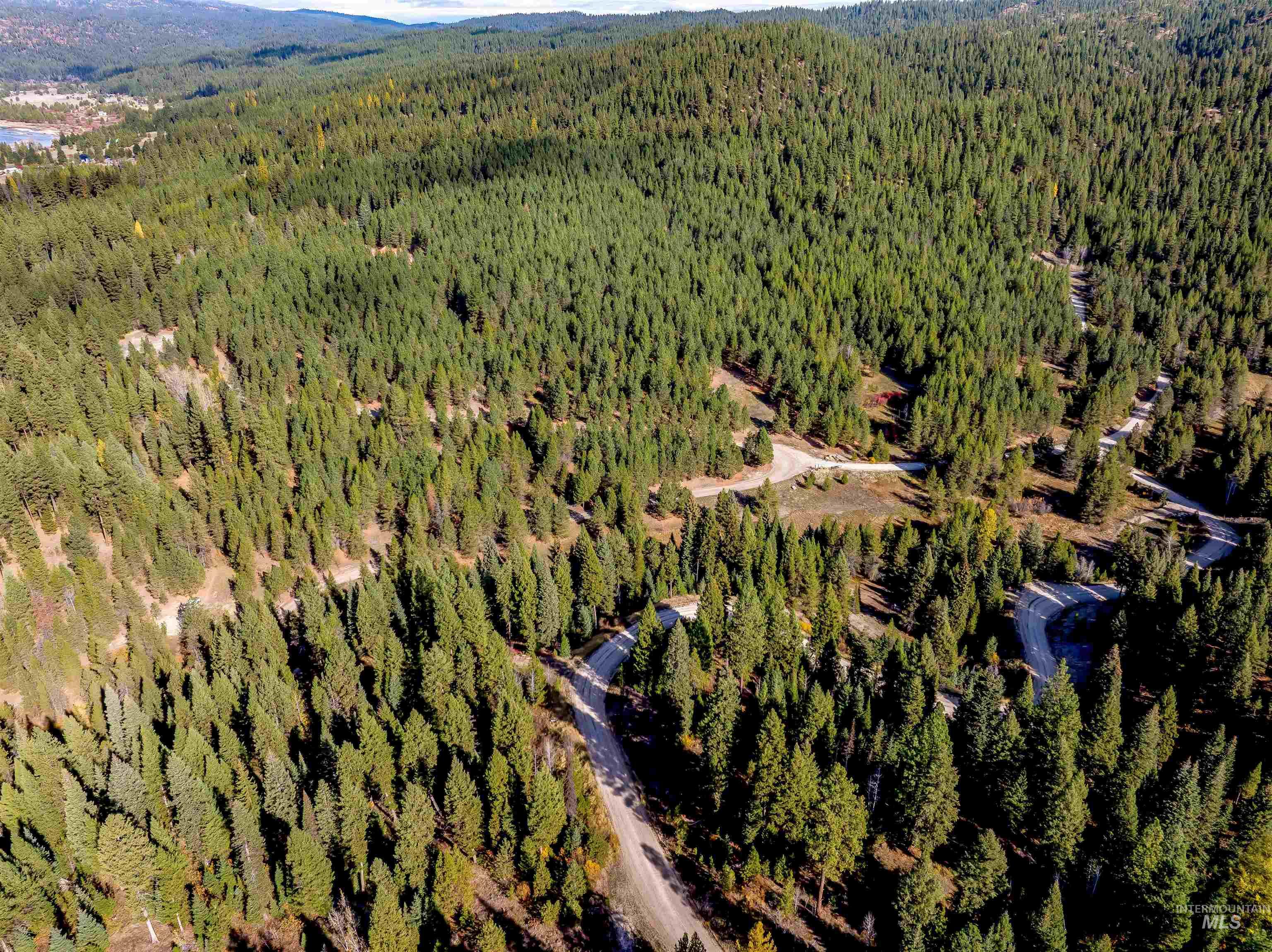 Aerial view of property and surrounding area with a heavily wooded area