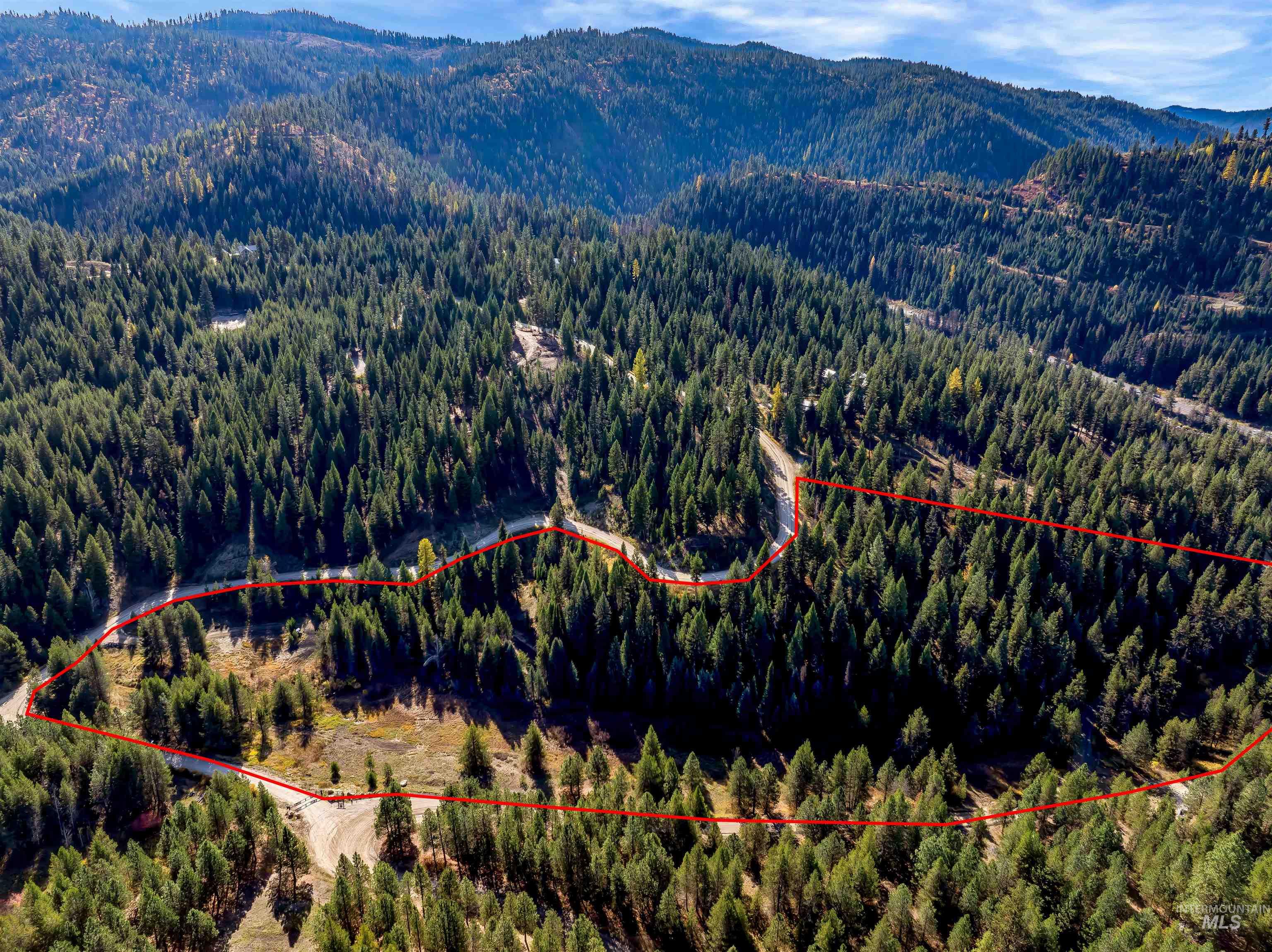 Aerial view of property's location featuring a mountainous background and property parcel outlined