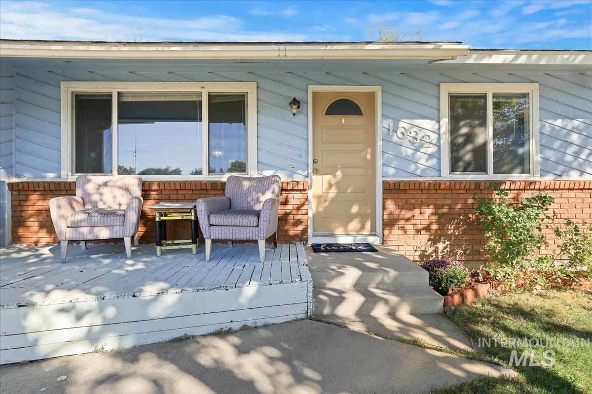 View of exterior entry featuring brick siding and outdoor lounge area