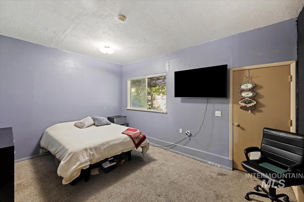 Bedroom featuring a textured ceiling and carpet floors