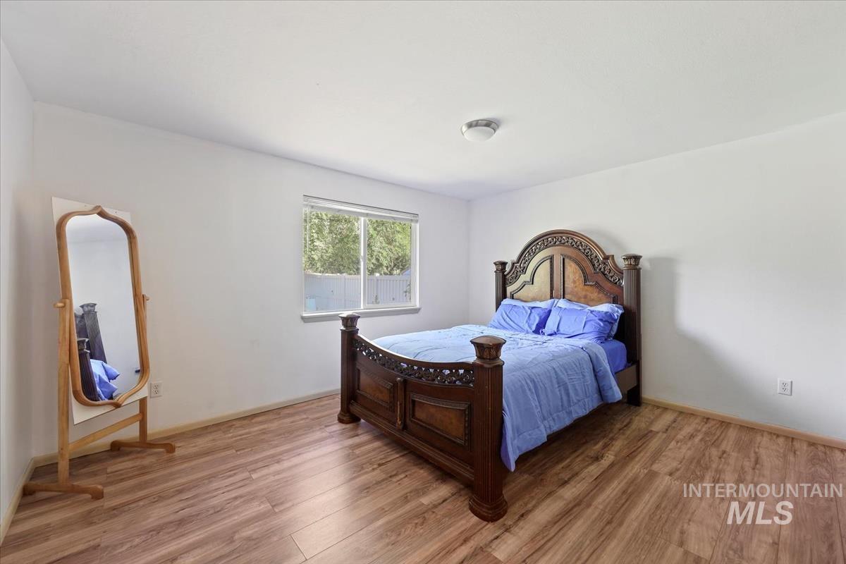 Bedroom with wood finished floors and baseboards