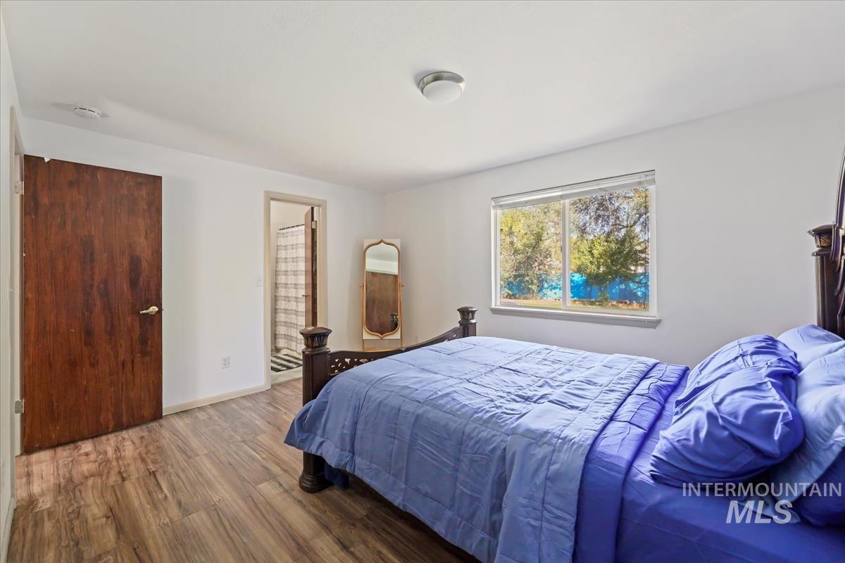 Bedroom with wood finished floors and ensuite bath