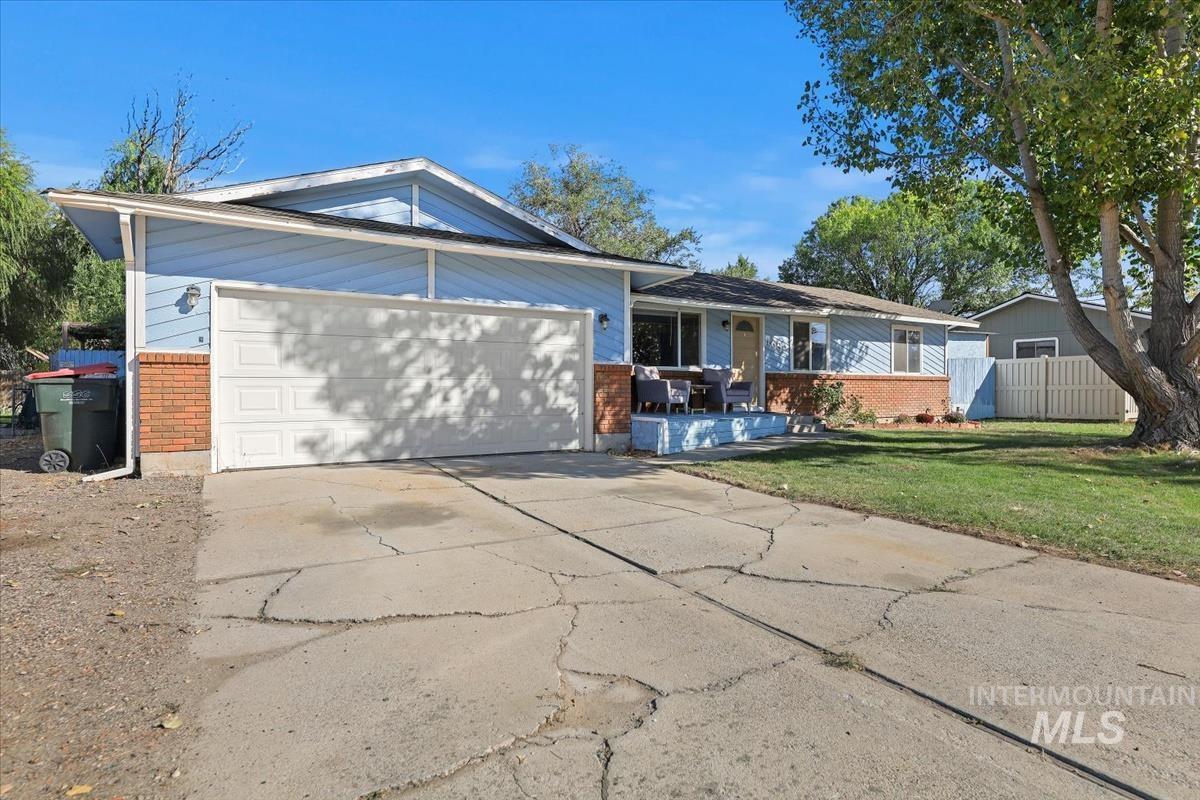 View of front of property featuring brick siding, concrete driveway, and an attached garage