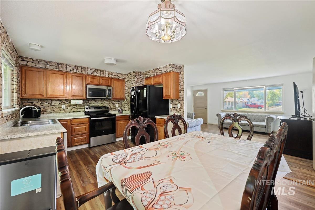 Dining area featuring dark wood-style floors and a chandelier