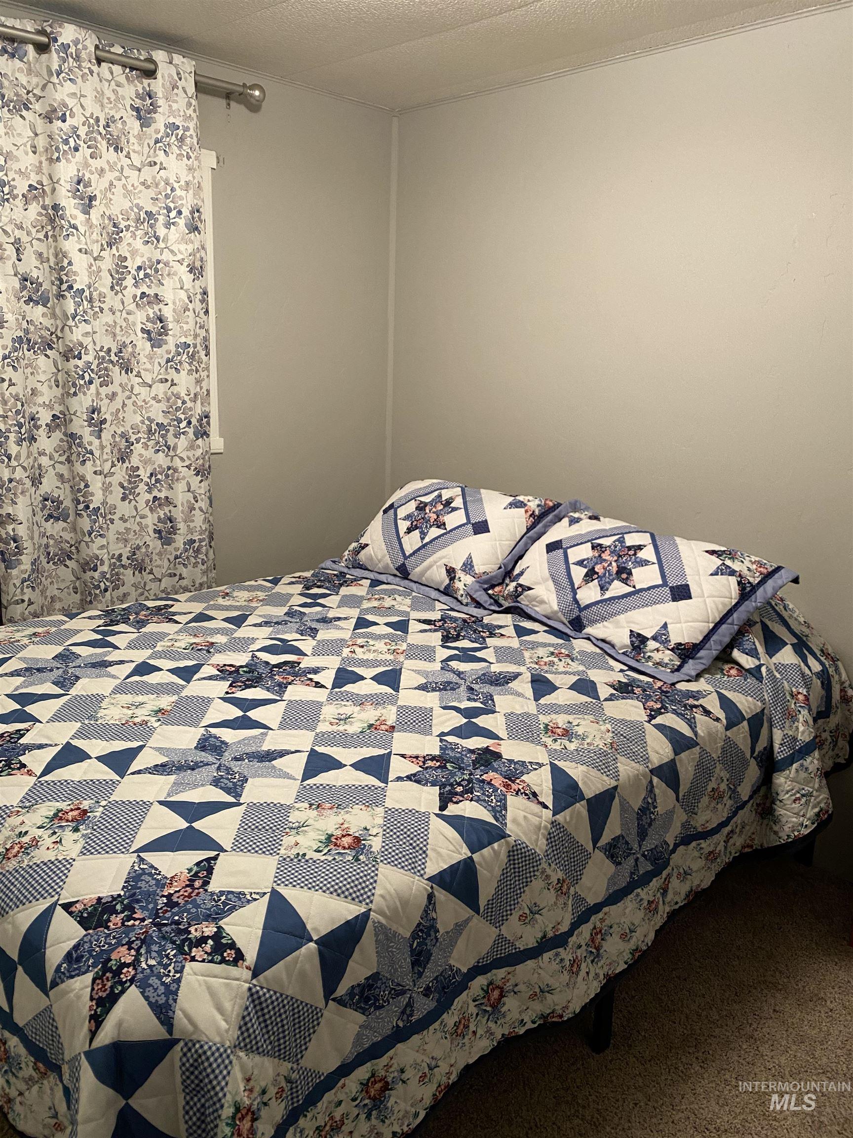 Bedroom with carpet floors and a textured ceiling