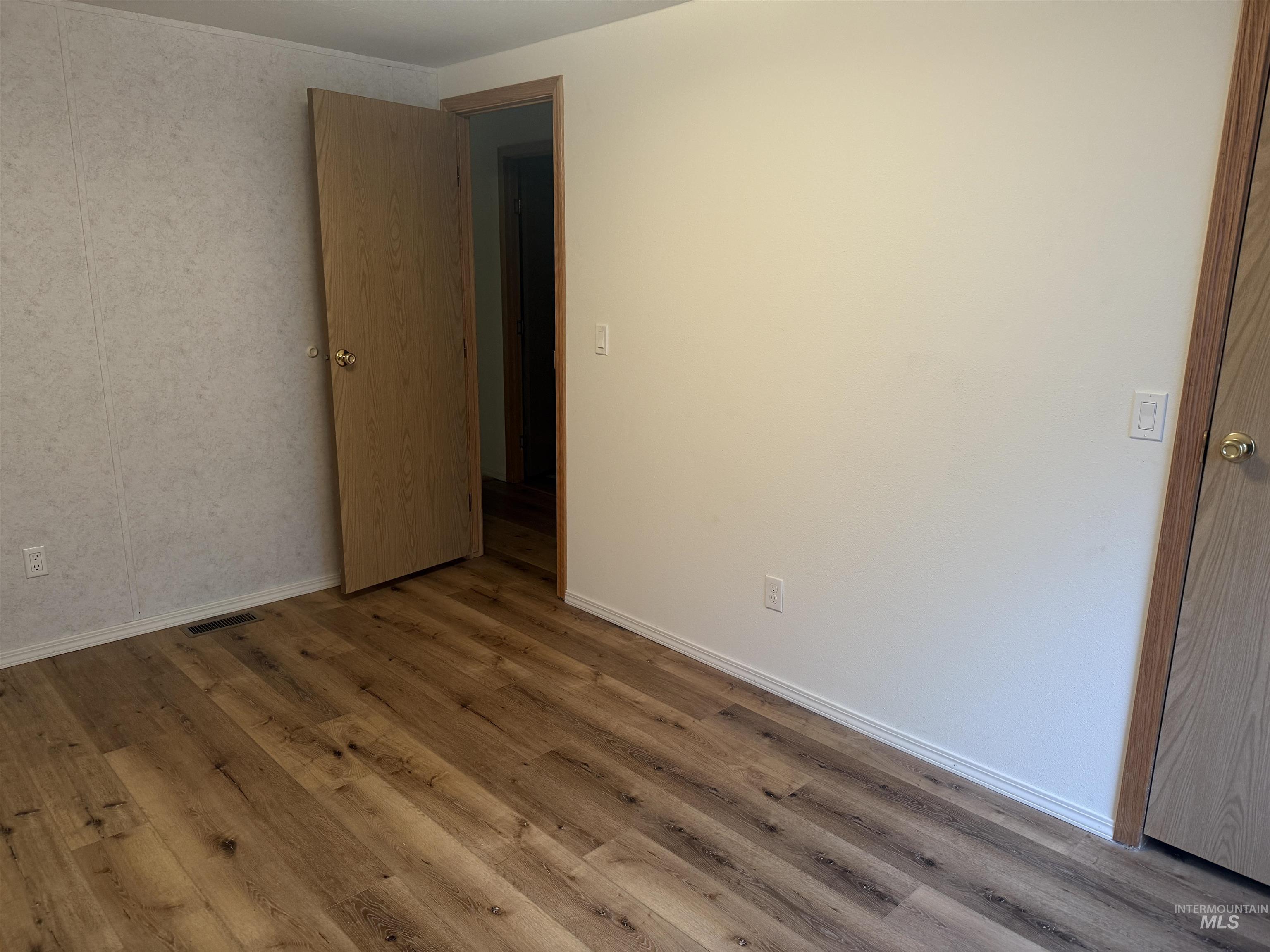 Spare room with wood finished floors and baseboards