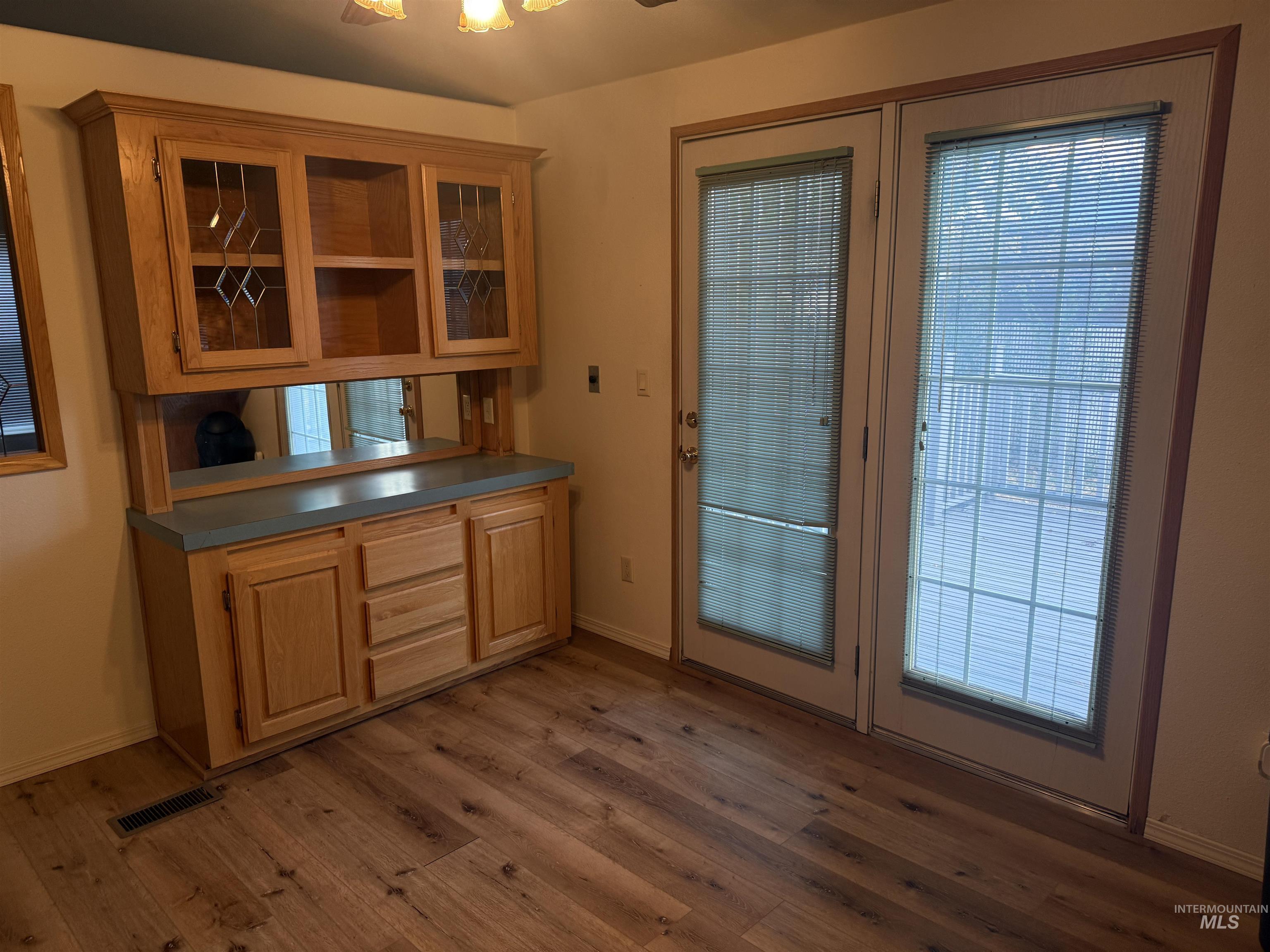 Doorway to outside with wood finished floors and a ceiling fan