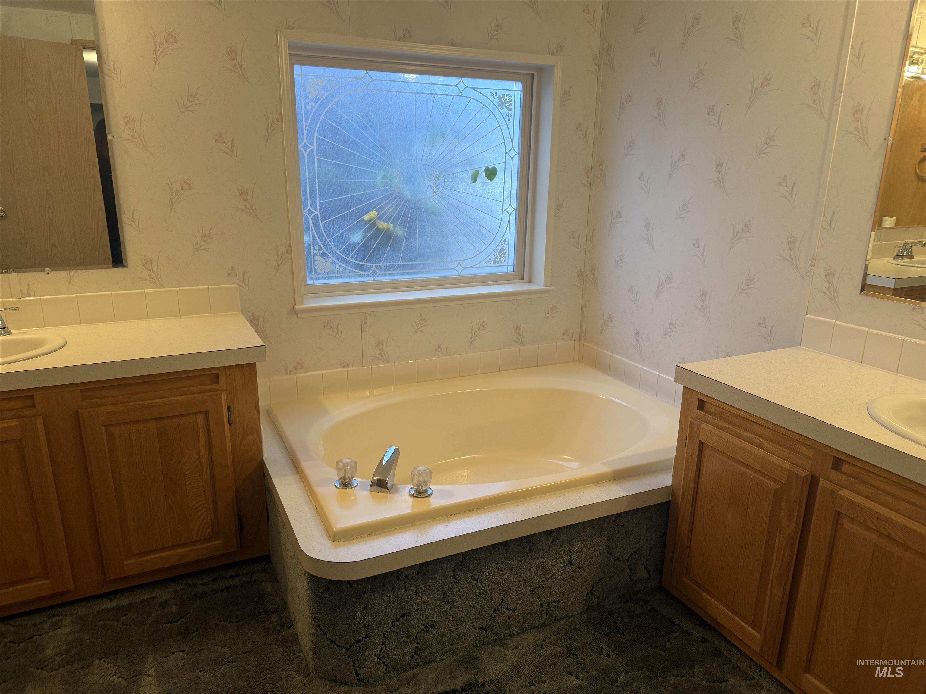 Bathroom with two vanities and a garden tub
