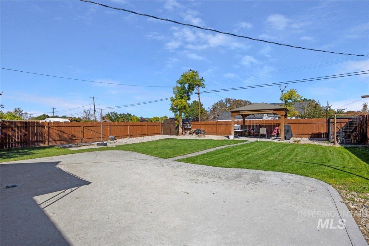 Fenced backyard featuring a gazebo and a patio area