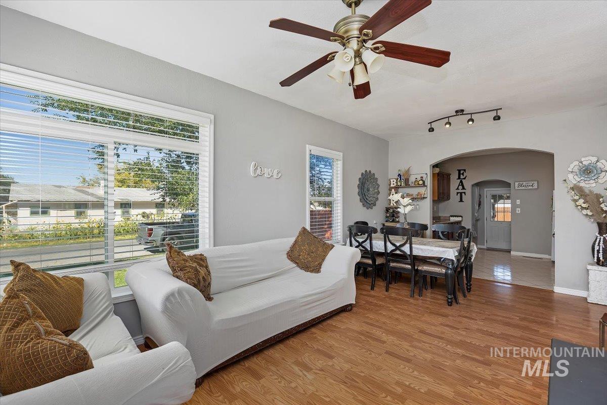 Living room featuring arched walkways, wood finished floors, and a ceiling fan