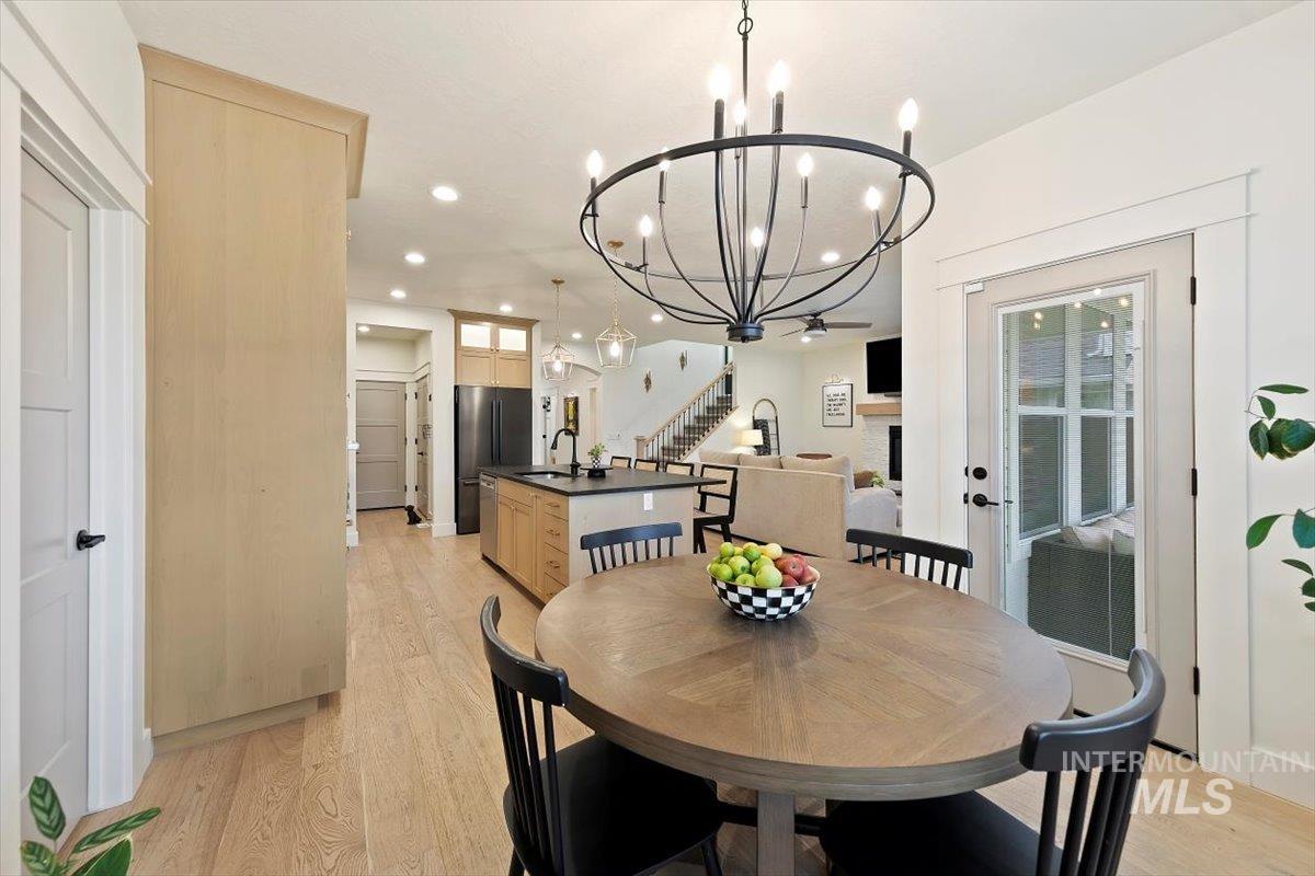 Dining area with stairway, light wood-style floors, a chandelier, and recessed lighting
