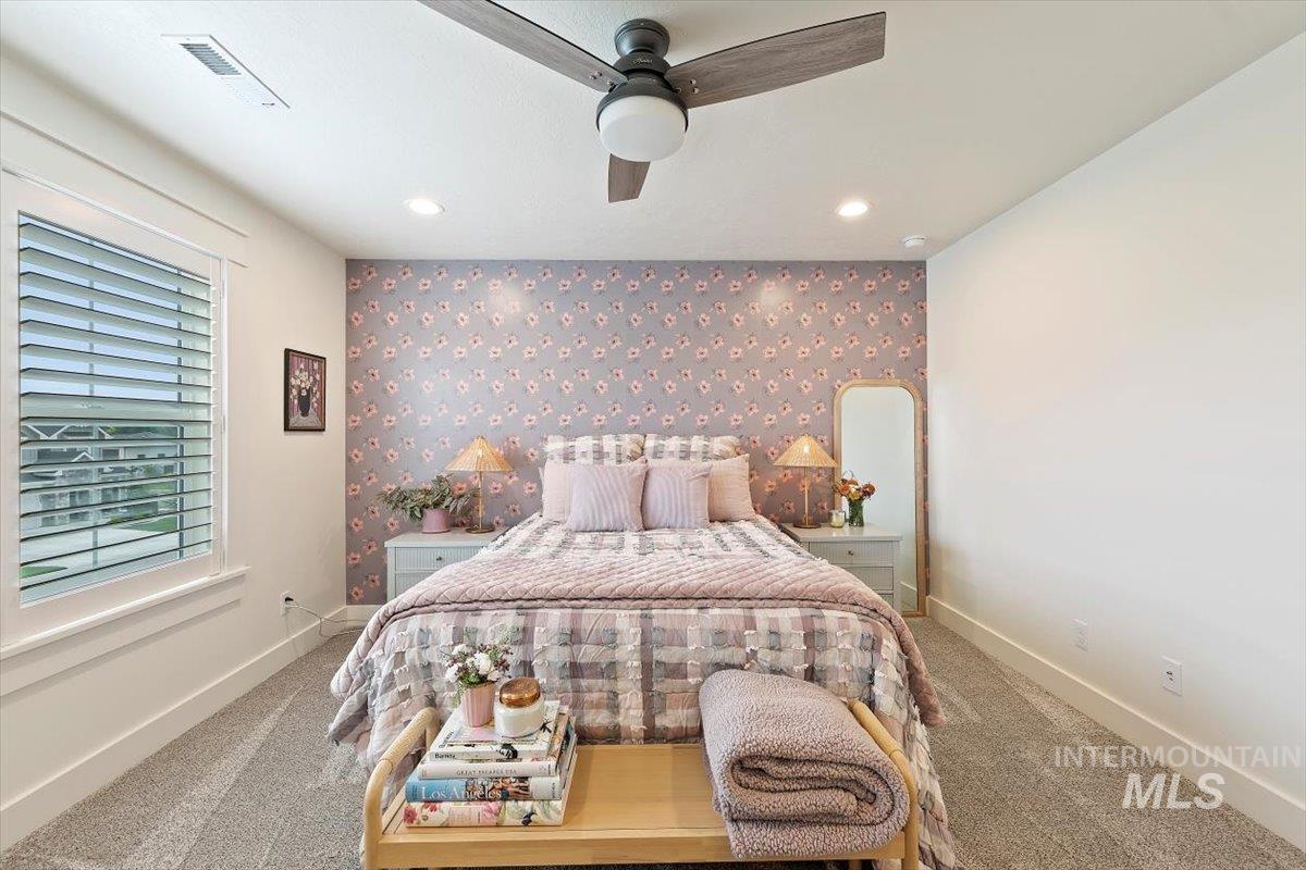 Bedroom featuring an accent wall, wallpapered walls, carpet, ceiling fan, and recessed lighting