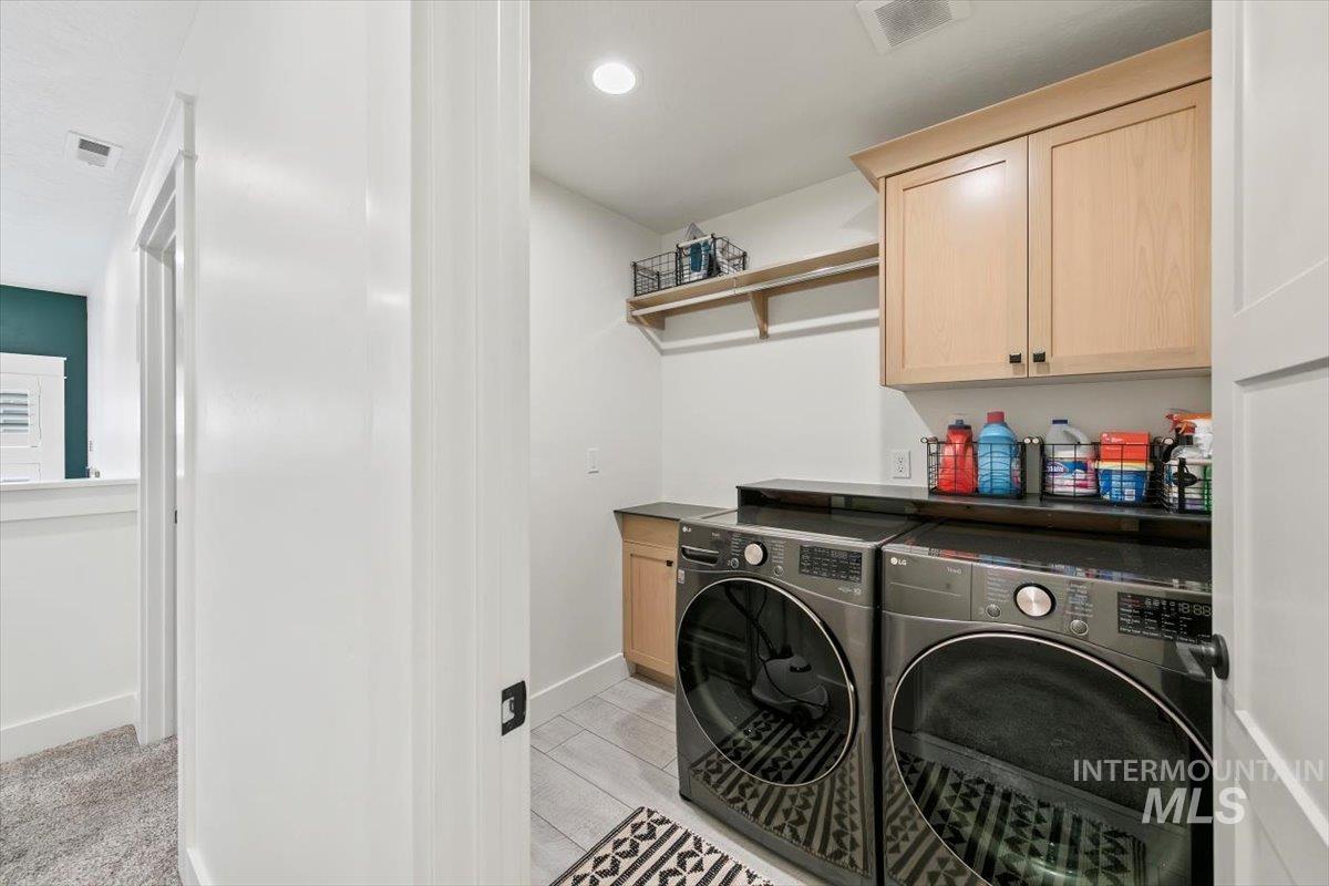 Laundry area featuring cabinet space, washer and dryer, light wood-style flooring, and recessed lighting
